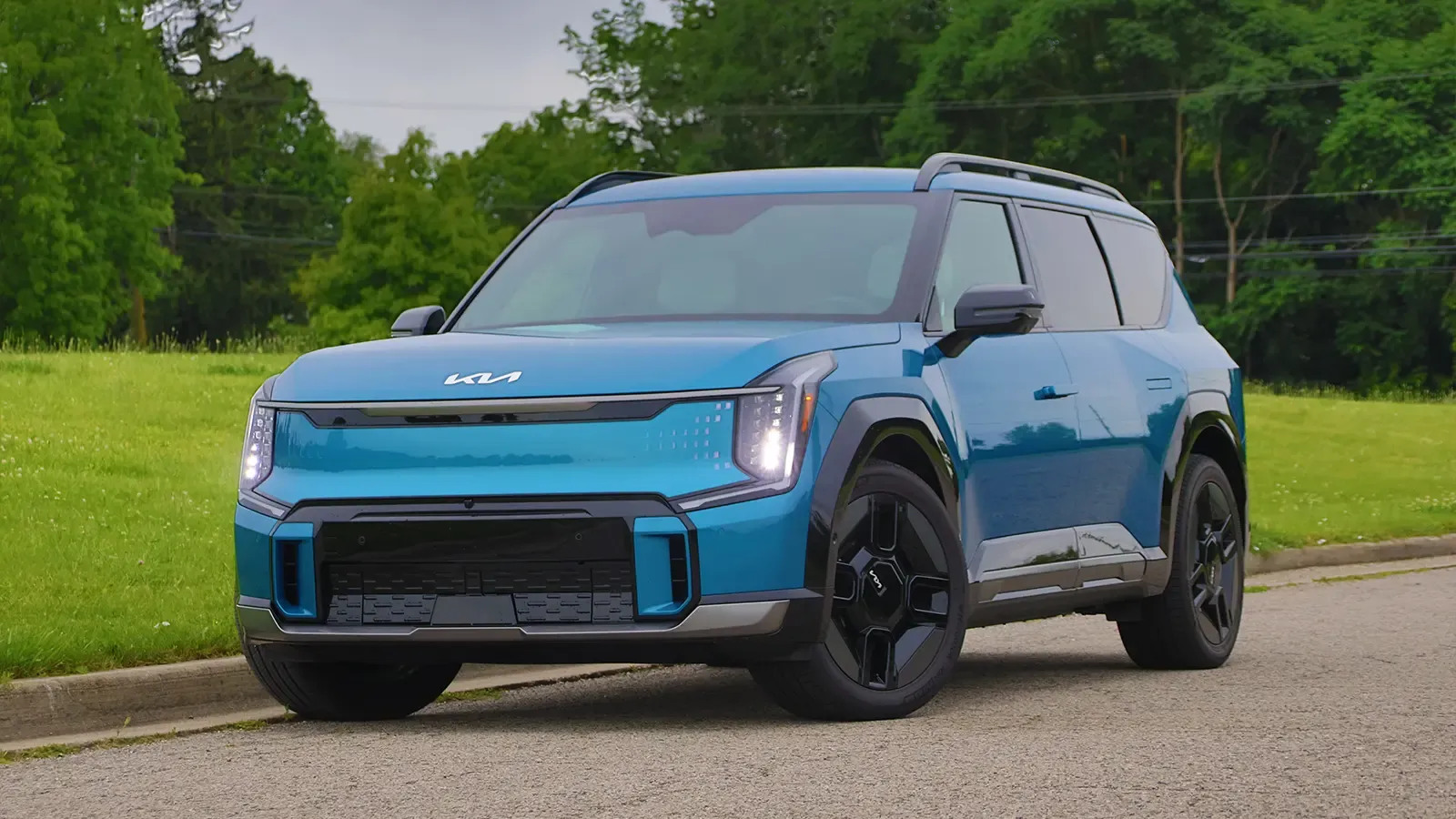 A blue 2026 Kia EV9 GT line three quarter front view