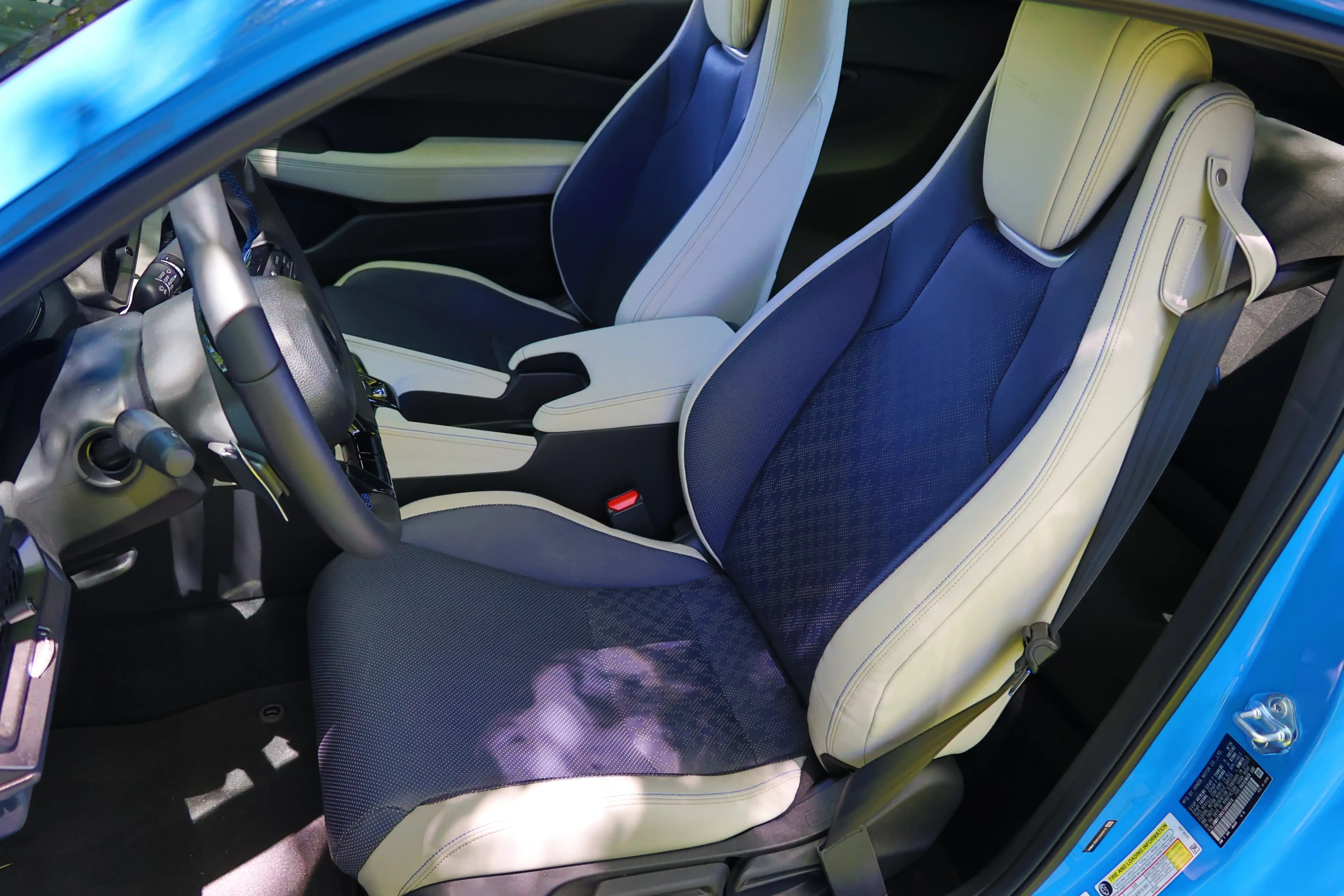 Asientos delanteros con tapicería azul y blanca y un apoyabrazos central en el Honda Prelude.