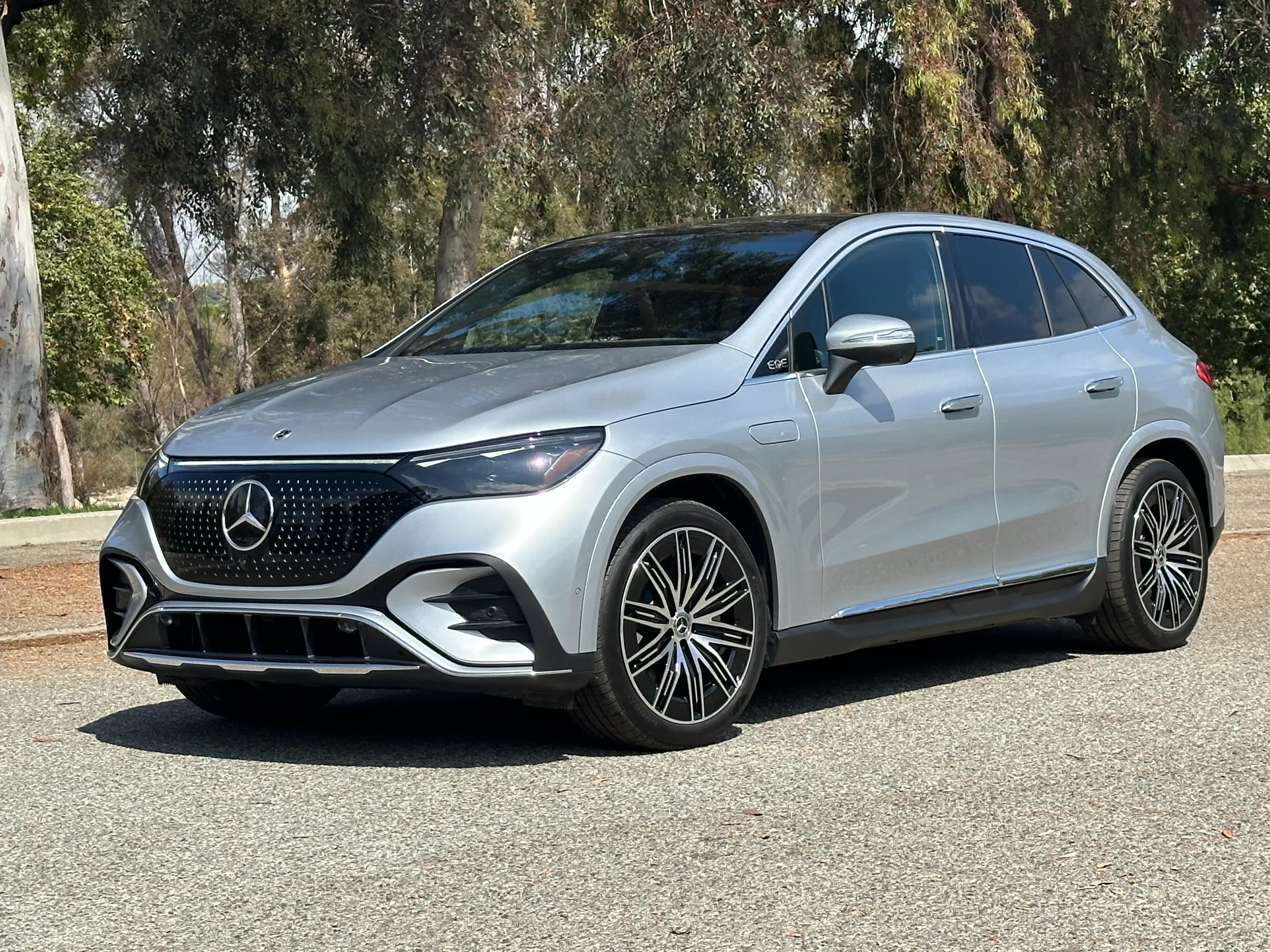 Front three-quarter view of a silver Mercedes-Benz EQE SUV parked outdoors.