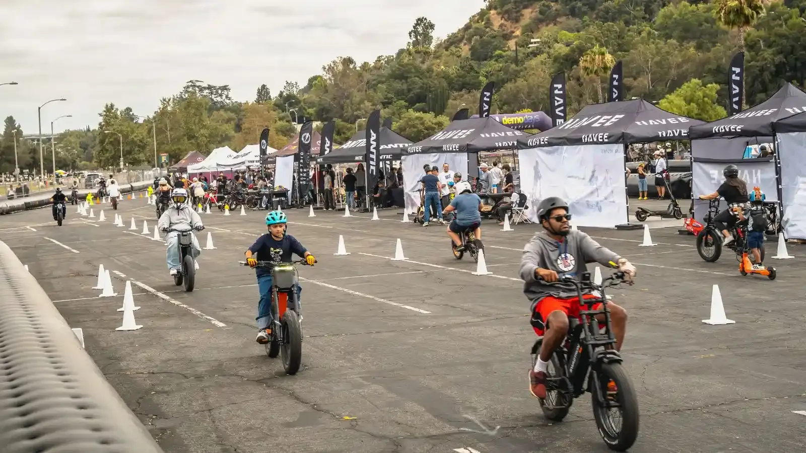 Outside the Rose Bowl many different ebikes and scooters are driving by a cone course