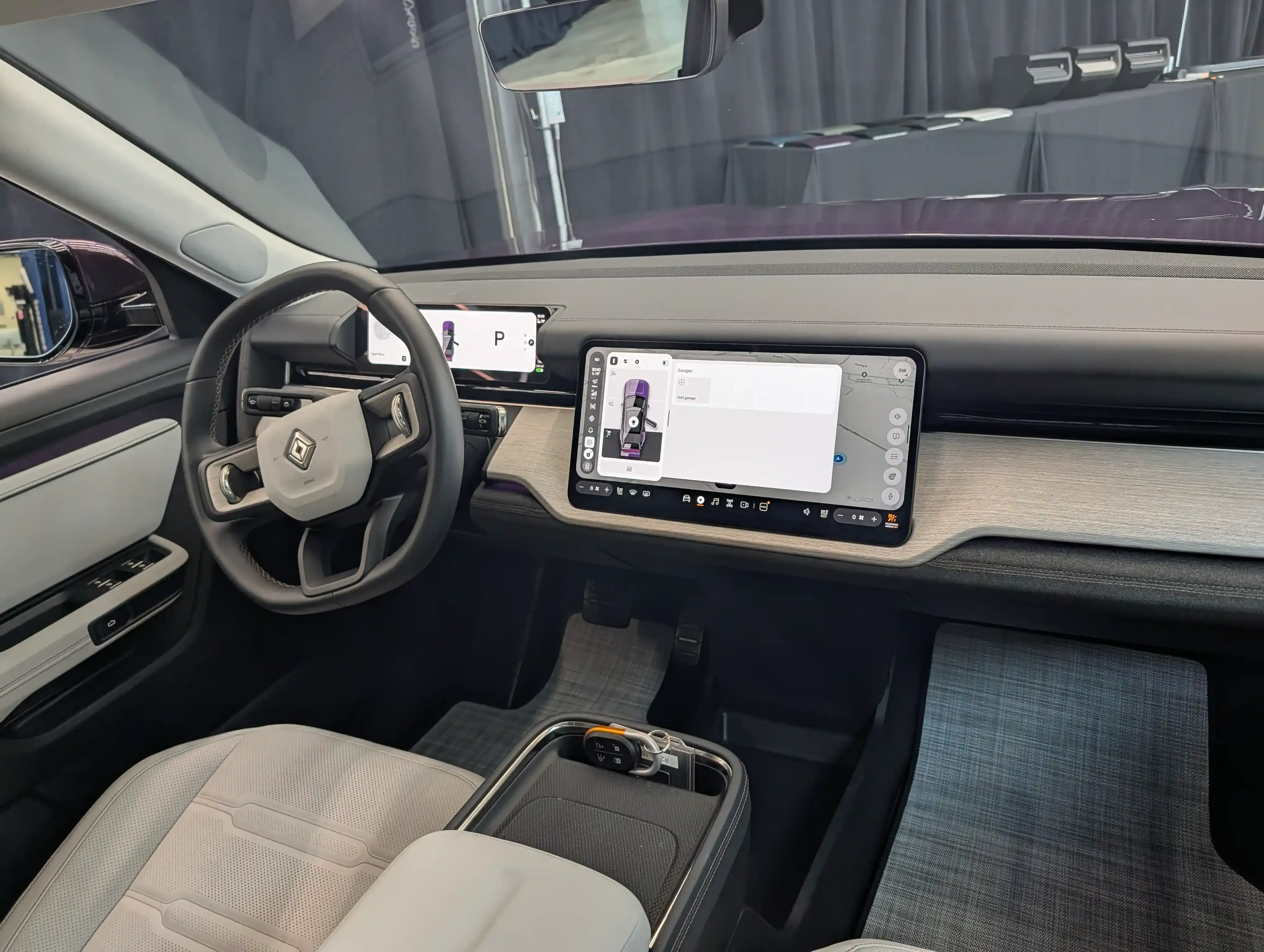Rivian R2 interior showing the front cabin with a digital instrument cluster and large center touchscreen.