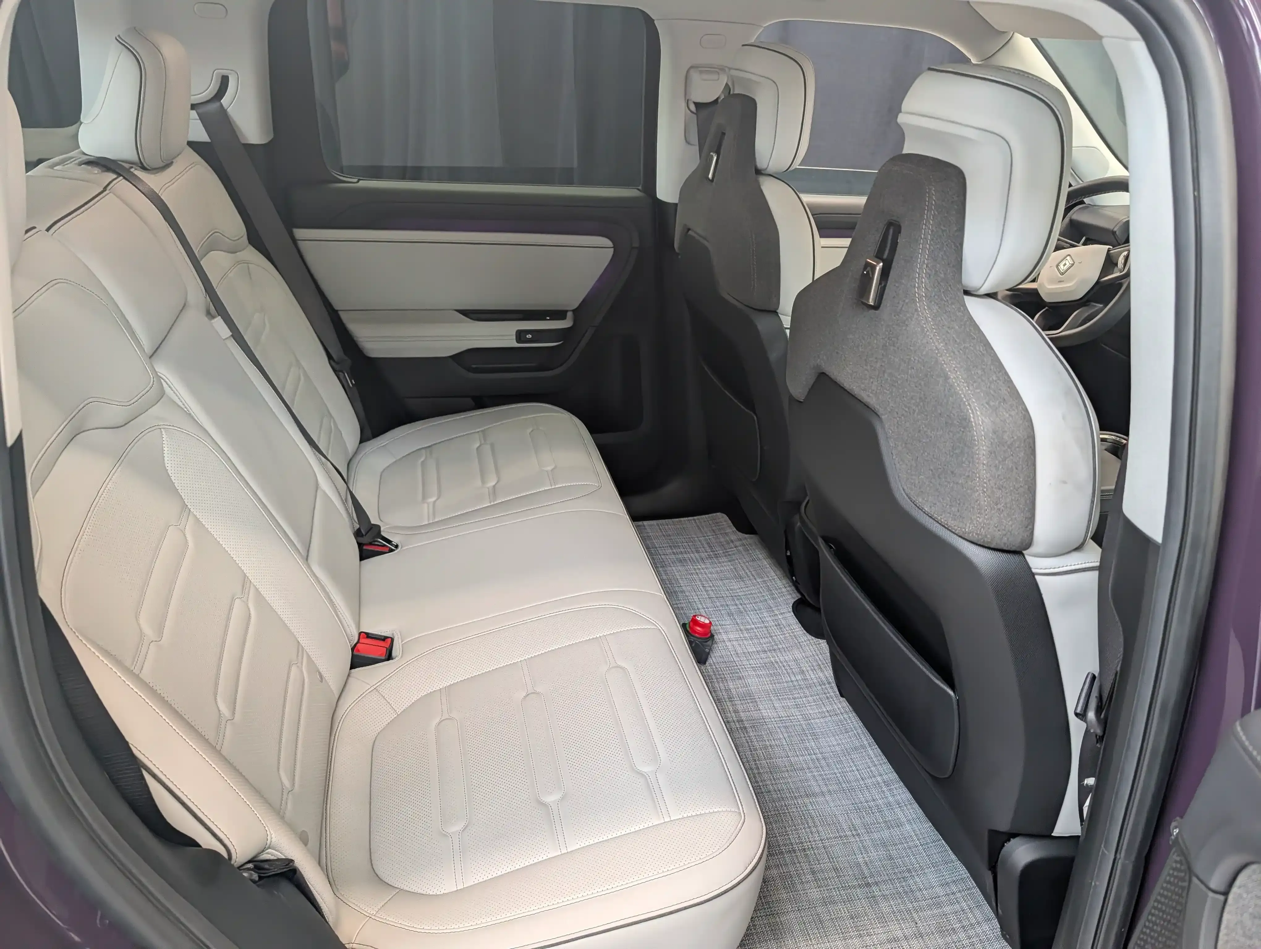 Rear seat view of a Rivian R2 cabin with light upholstery and a flat floor.