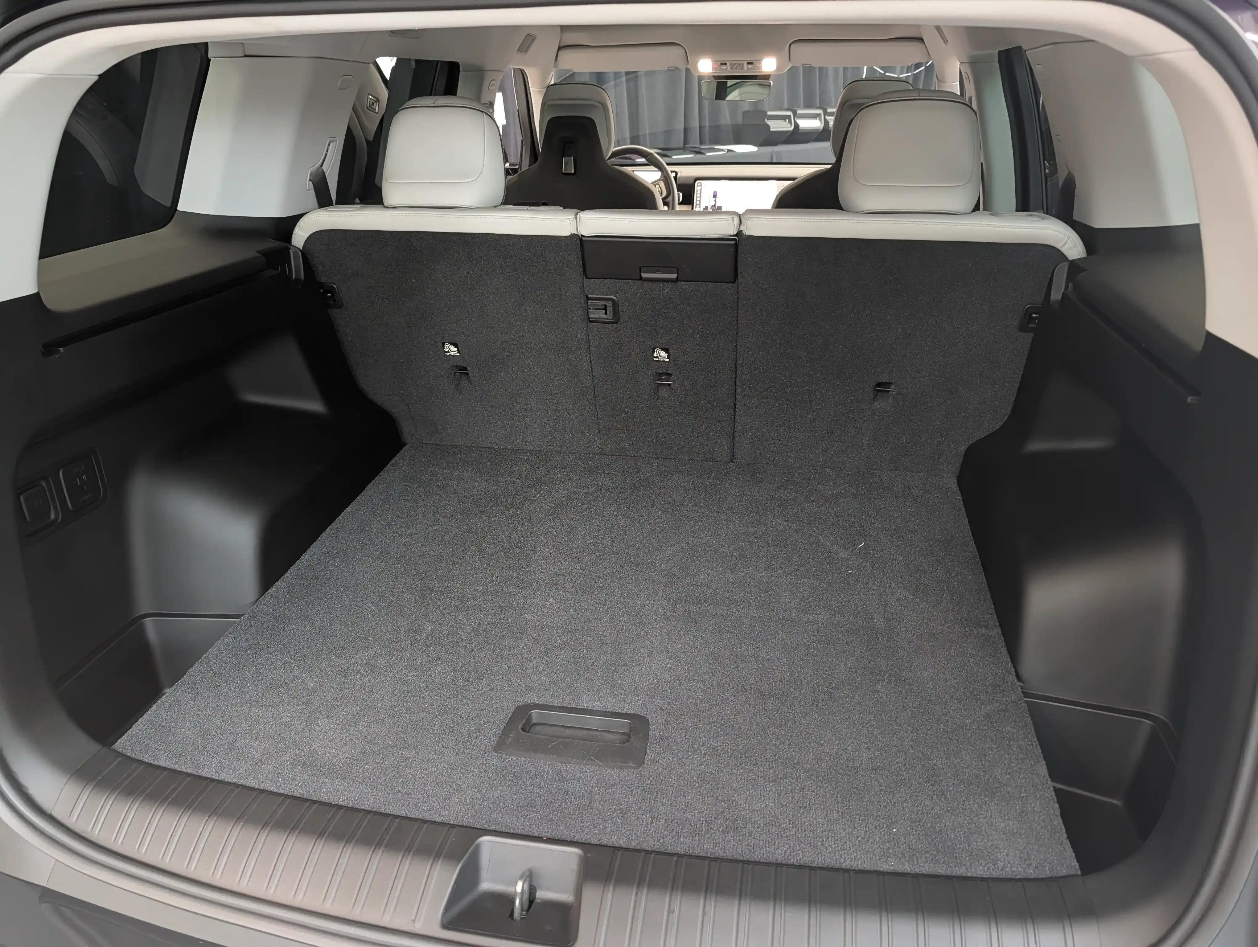 Open rear cargo area of a Rivian R2 with the third row folded flat.
