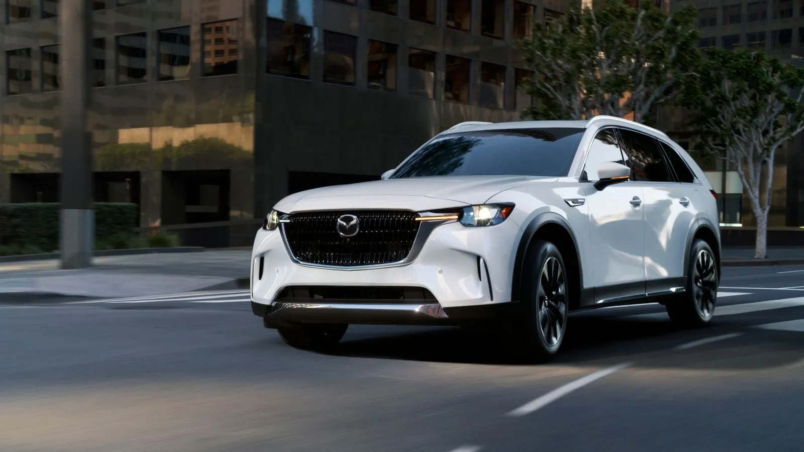 A white 2026 Mazda CX-90 PHEV sitting in a parking lot at an angle.