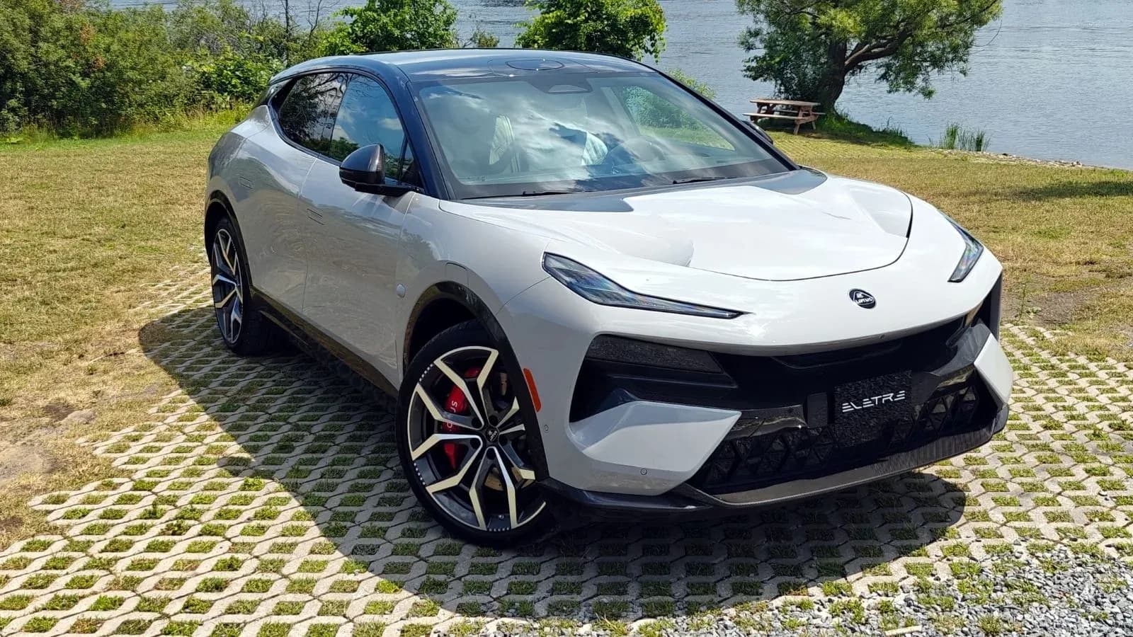 Silver 2026 Lotus Eletre sitting at an angle on broken concrete in front of a body of water
