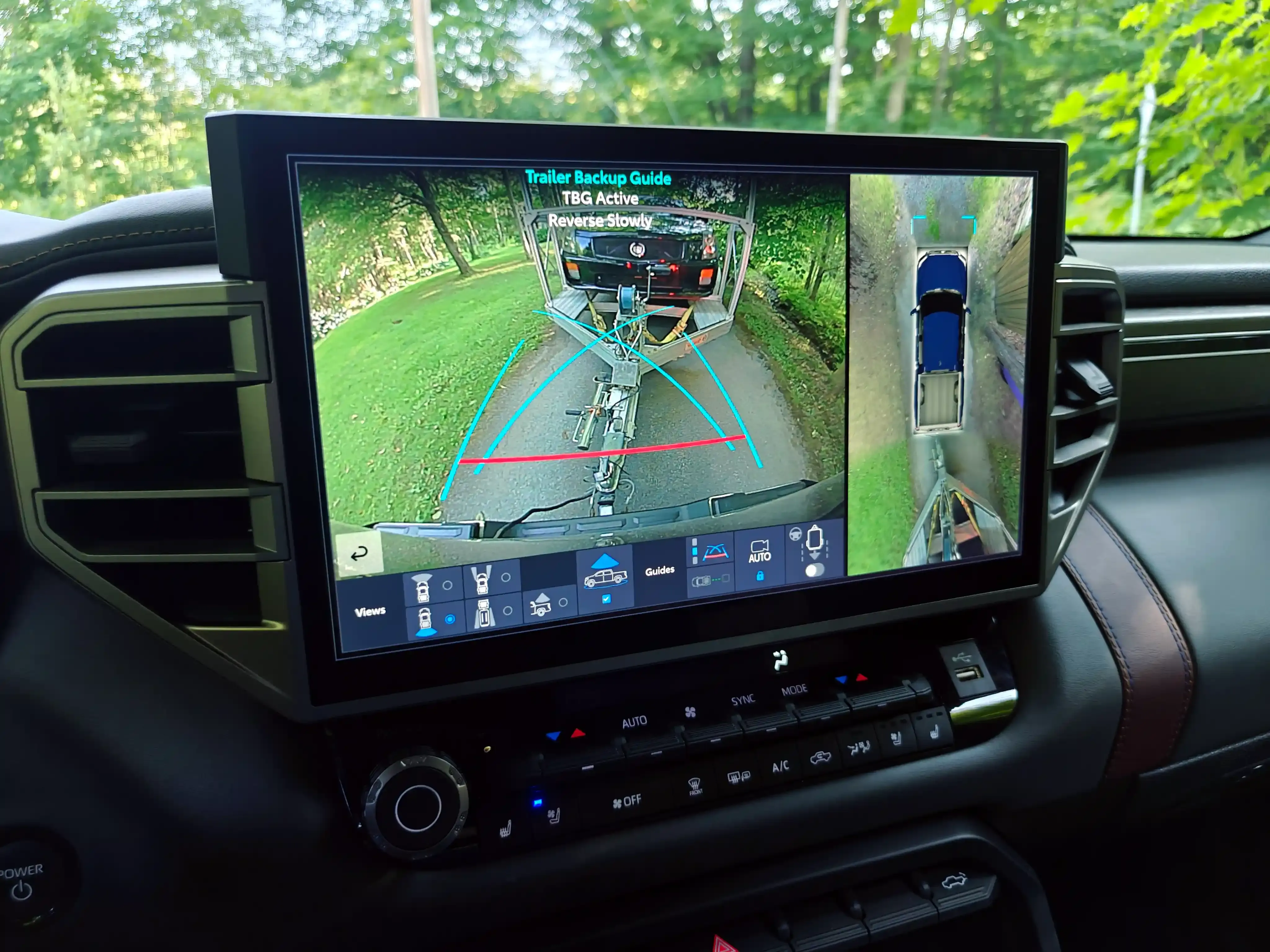 La pantalla del tablero de una Toyota Tundra muestra una guía para retroceder con remolque, con cámaras y líneas de dirección.
