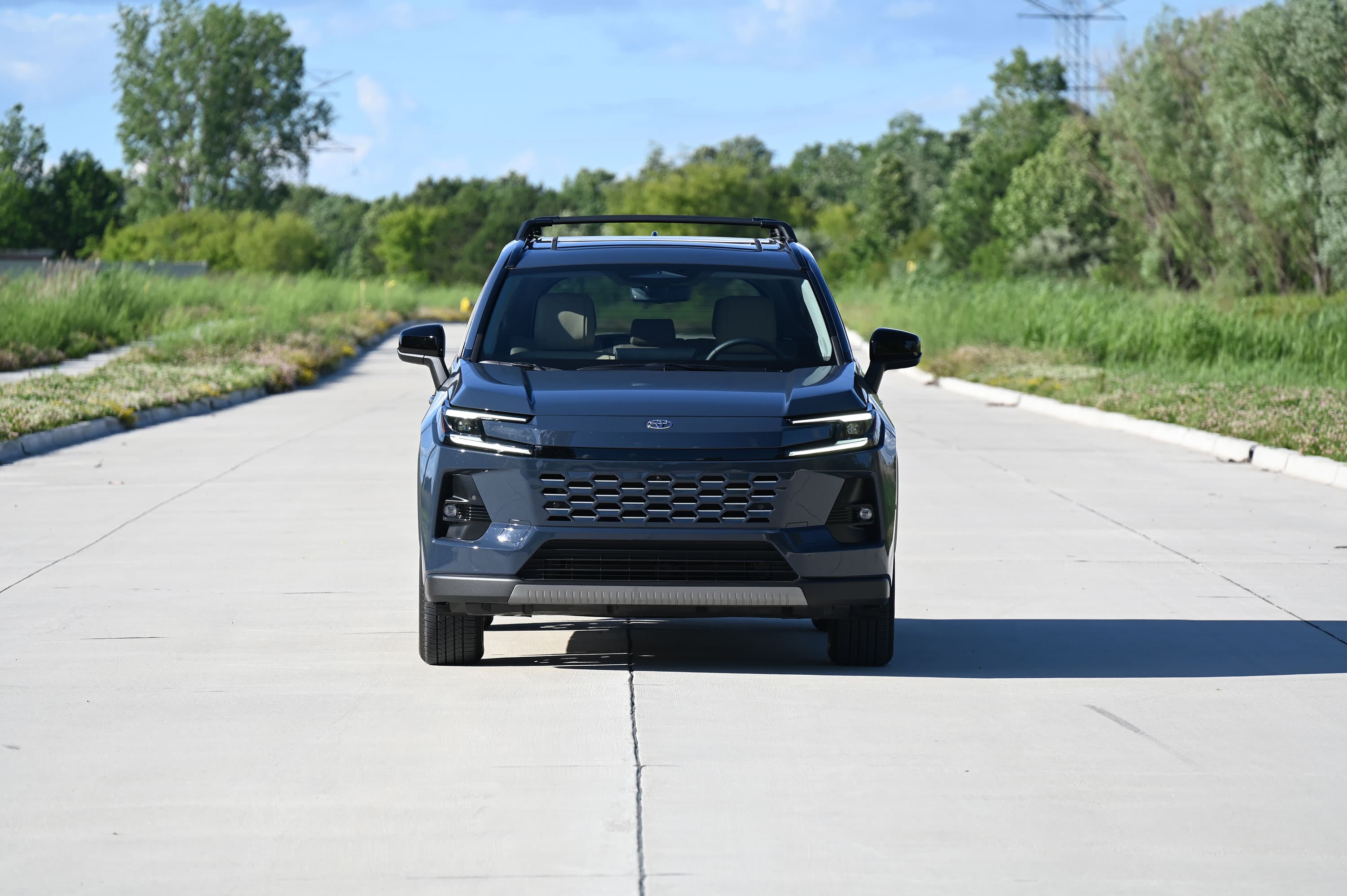 Vista frontal de una Toyota RAV4 Hybrid azul en una carretera.