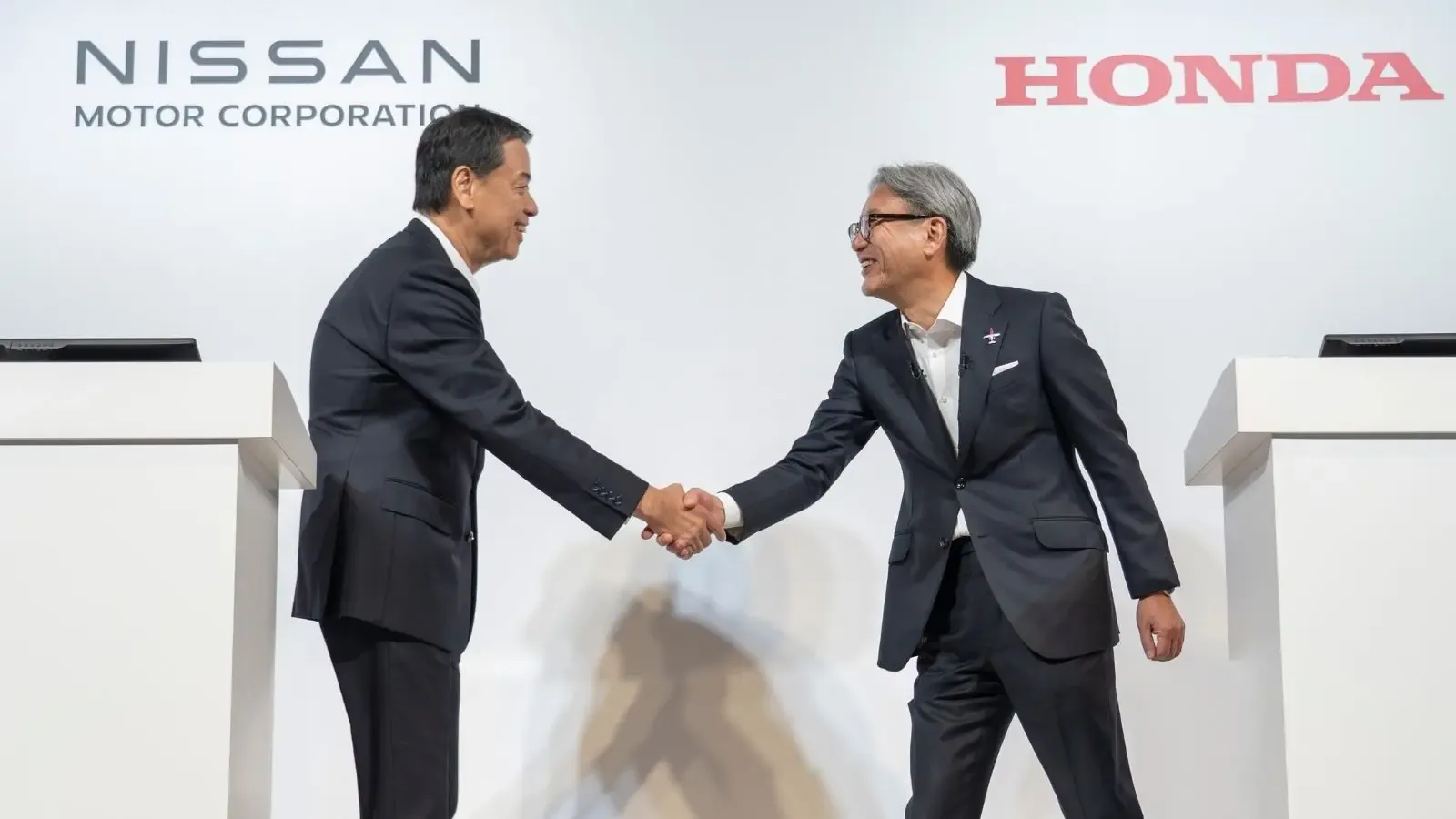 Photo from Nissan and Honda Joint Press Conference of Executives shaking hands