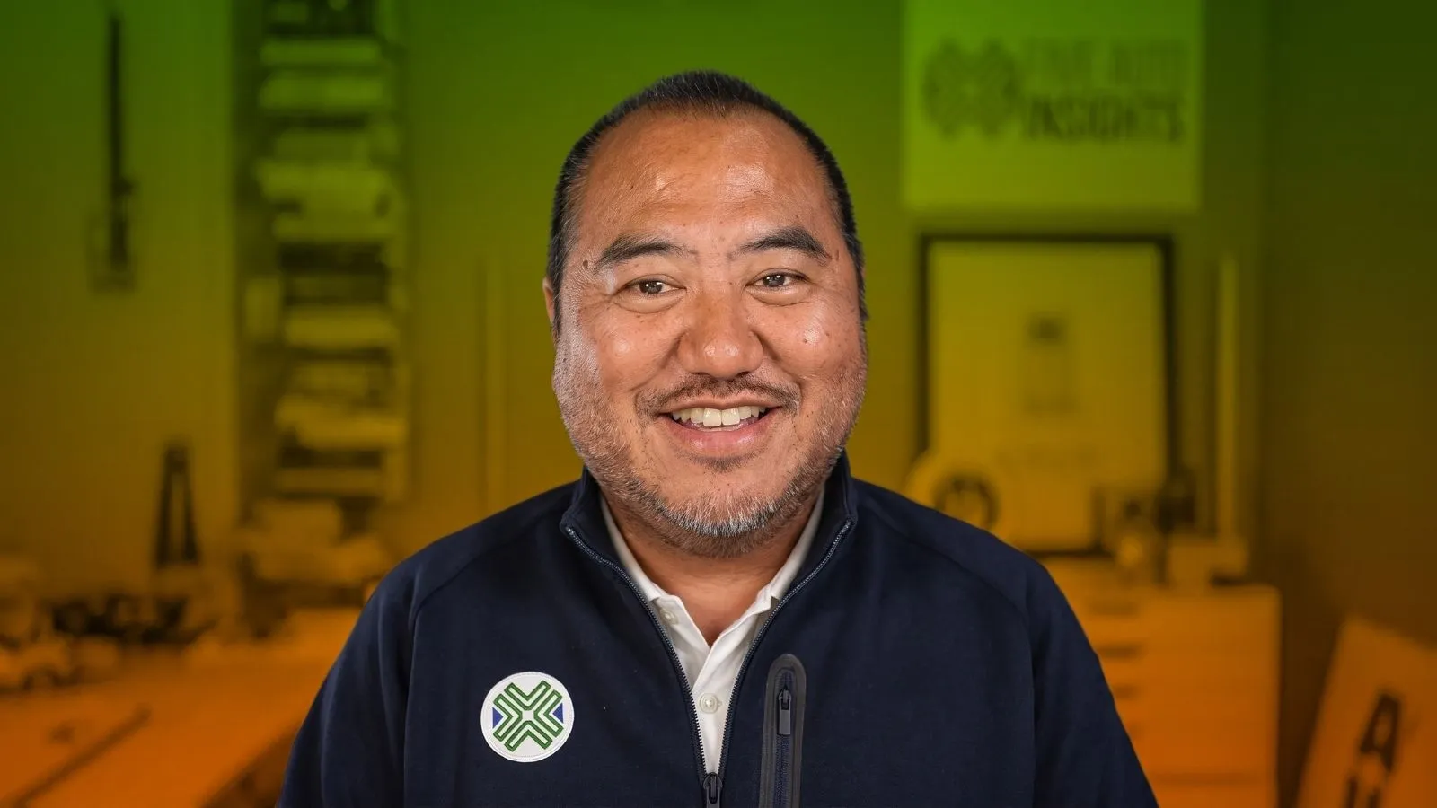 Tu Lee, Founder of Sino Auto Insights, pictured in front of a green and orange background.