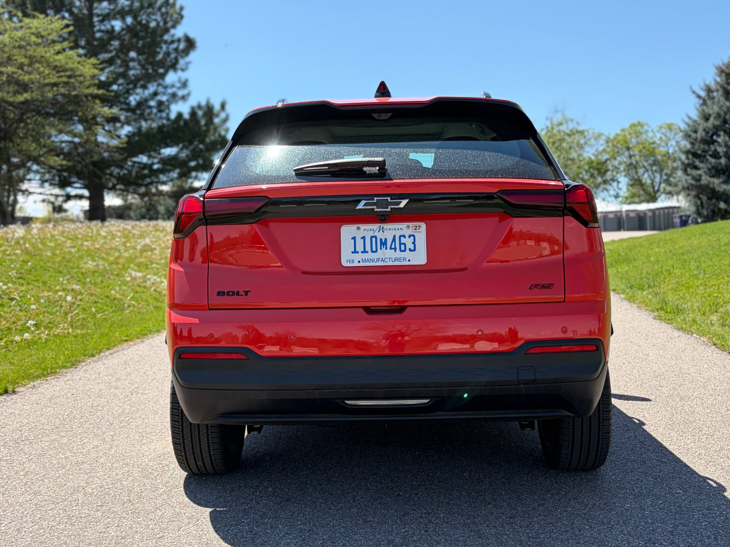 Rear view of a red Chevrolet Bolt RS showing its connected taillights, Chevrolet bowtie and Bolt and RS badges.