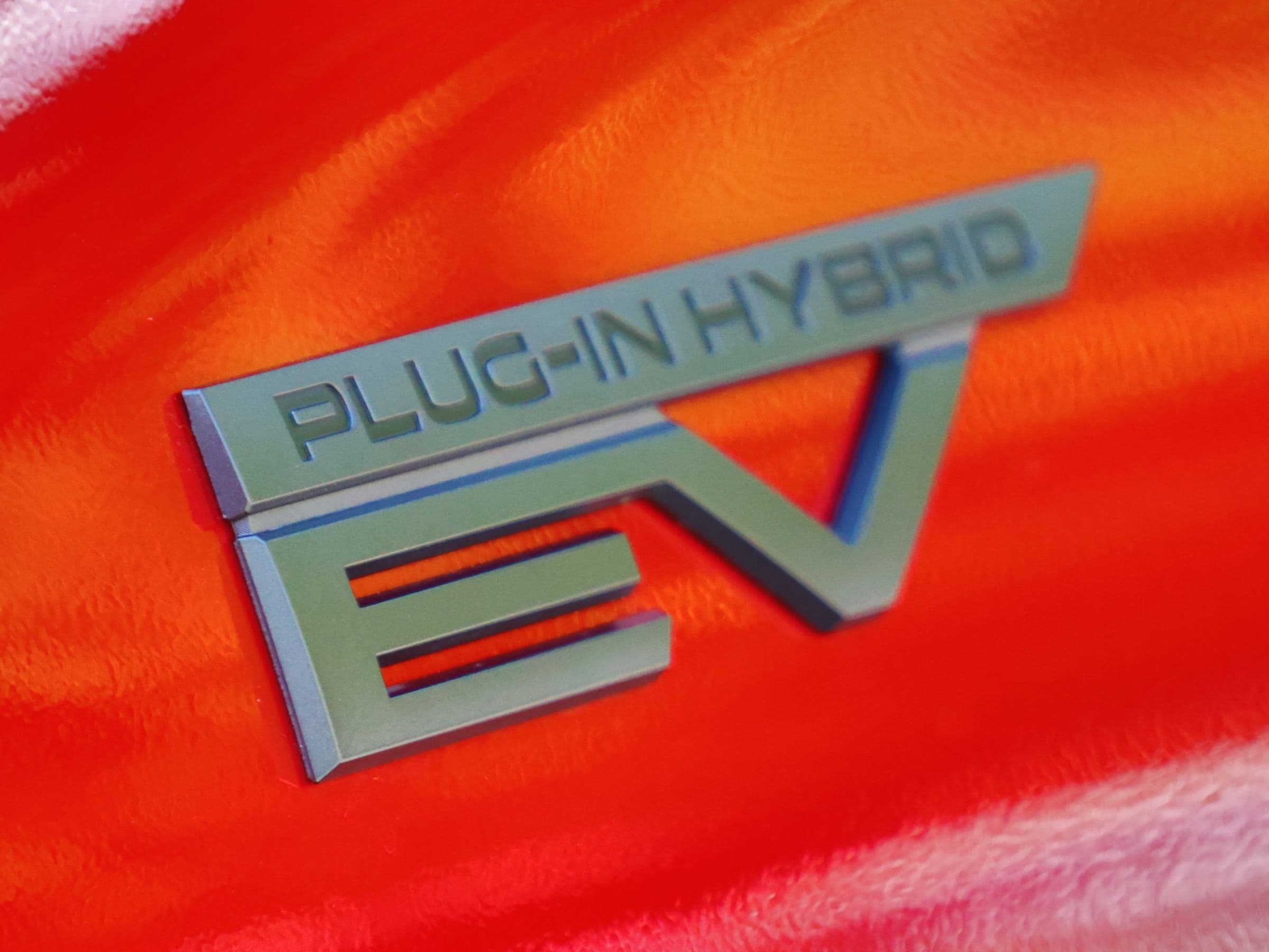 A close-up image of the badging for a red 2026 Mitsubishi Outlander PHEV 
