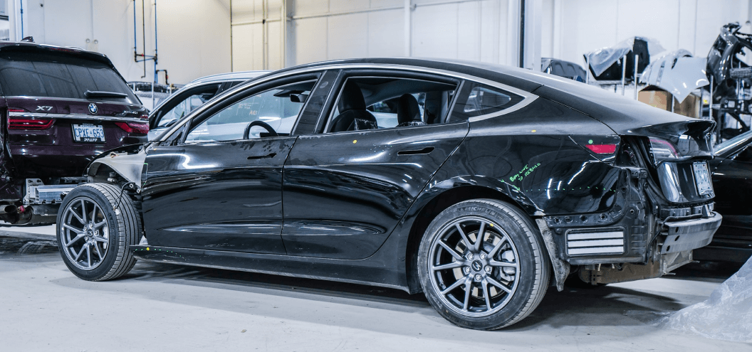 Damaged Black Tesla Model 3 at repair shop