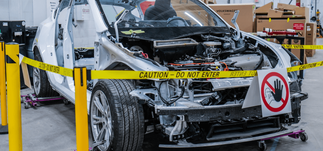 Damaged White EV at repair shop hood profile