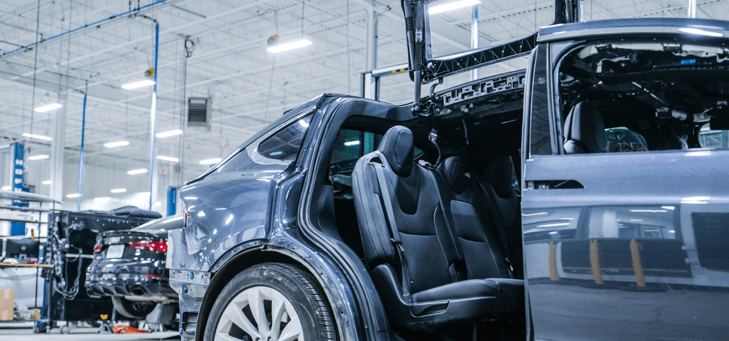 Damaged Tesla Model X at repair shop back seat profile