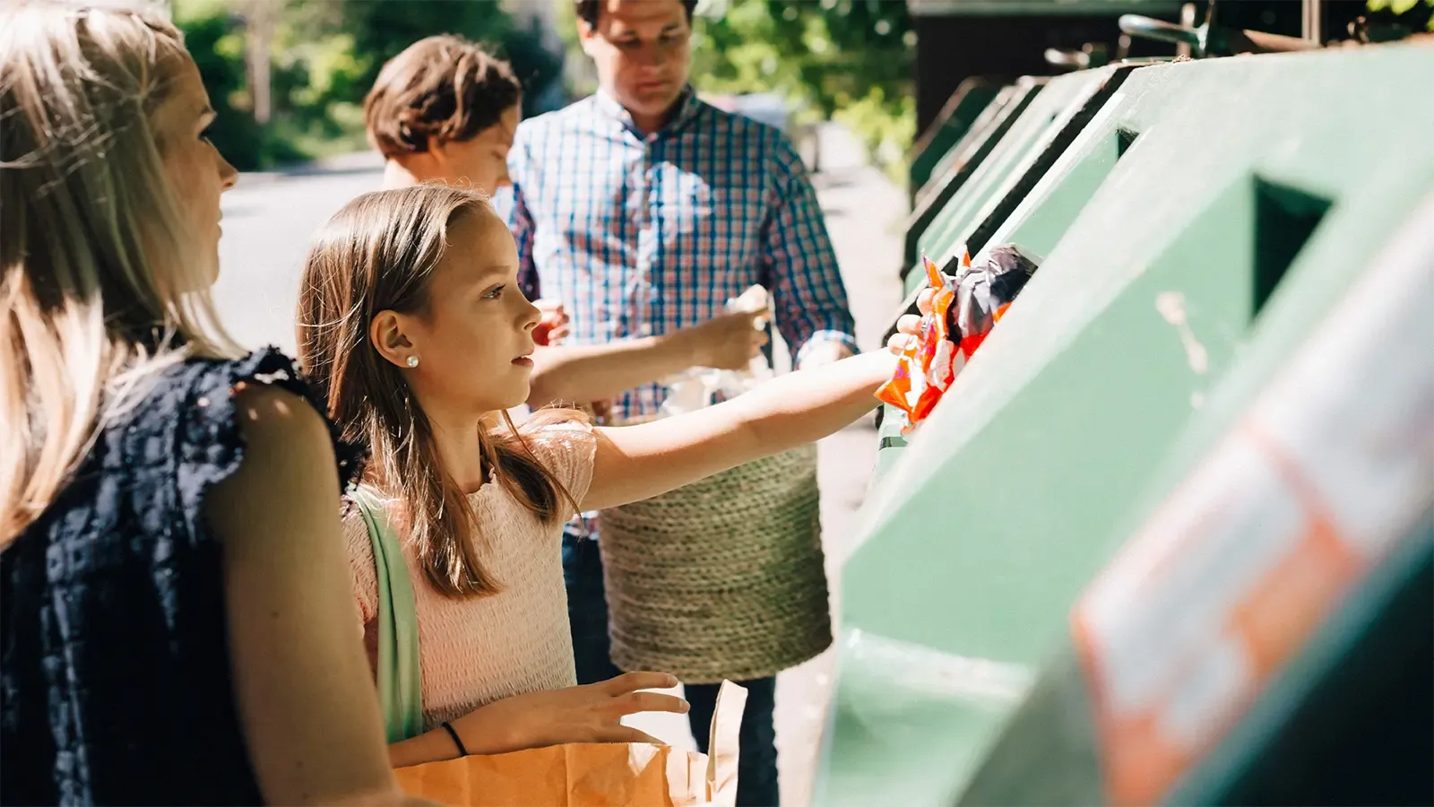A family putting their recycling into the recycle bin
