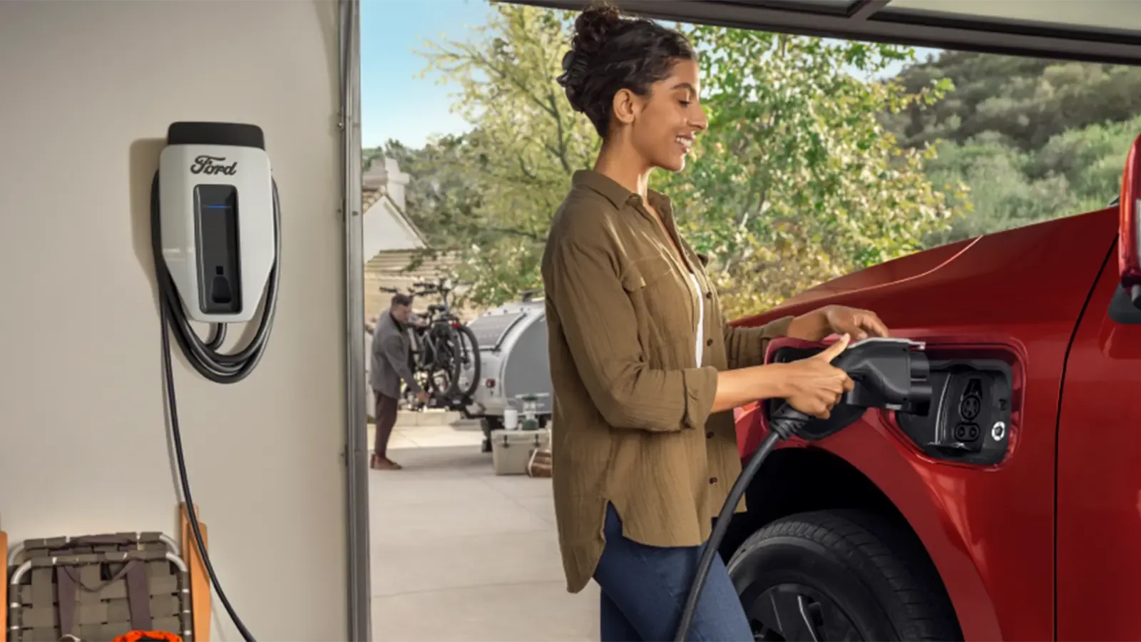Woman plugging in electric truck in garage