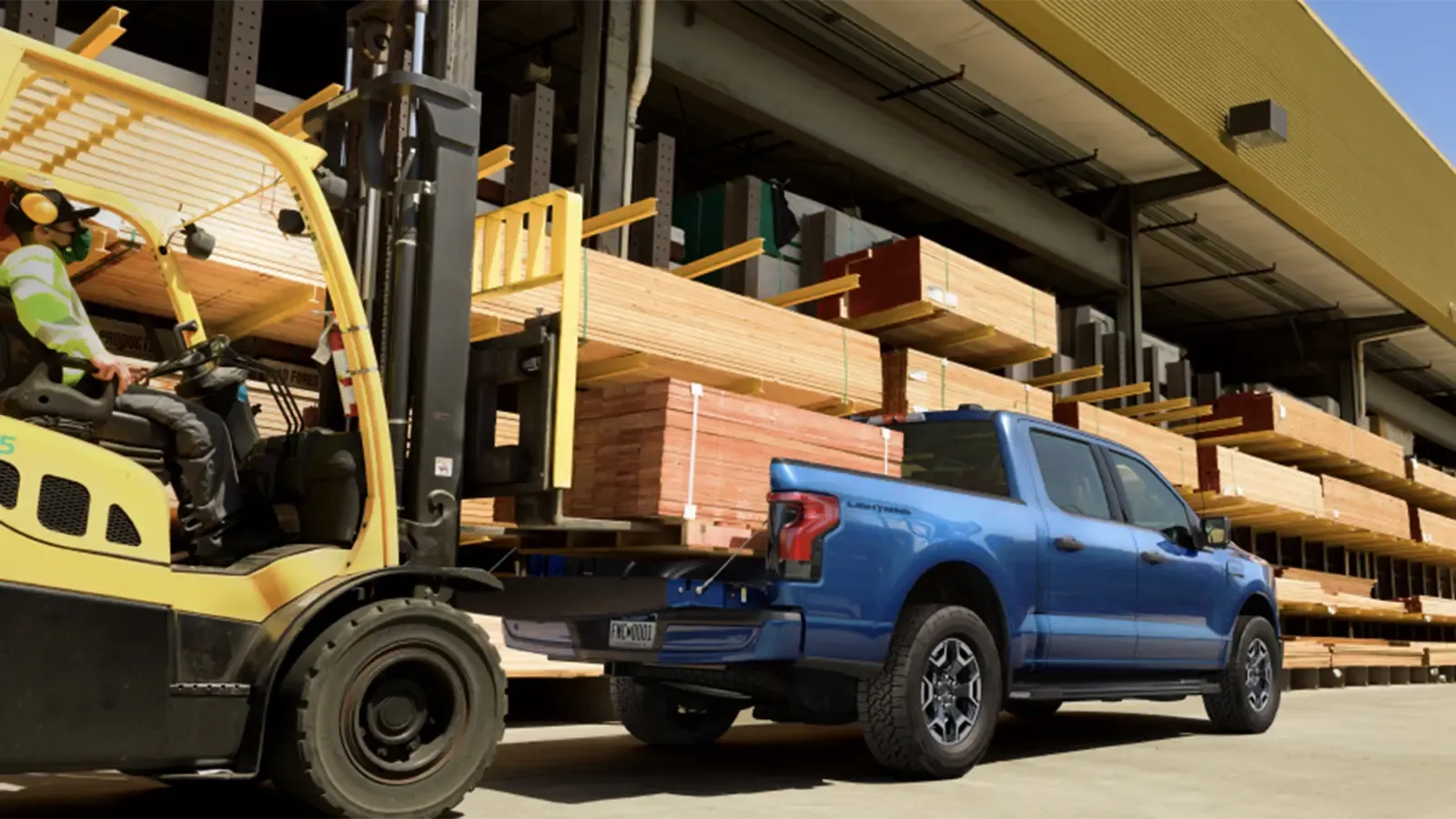 Ford electric truck with fork lift putting wood in the bed