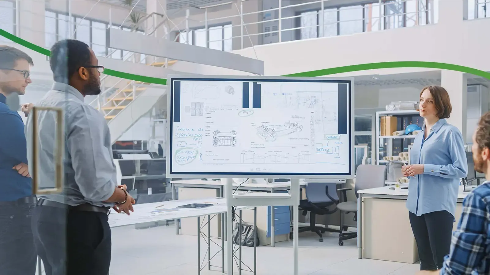 Group of workers in conversation circle around whiteboard in office