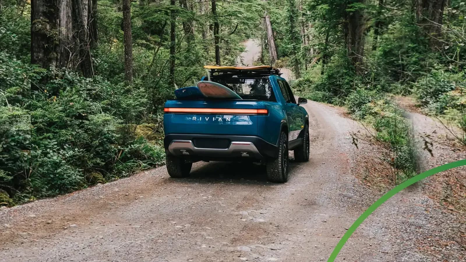Rear view of Rivian truck driving up dirt road