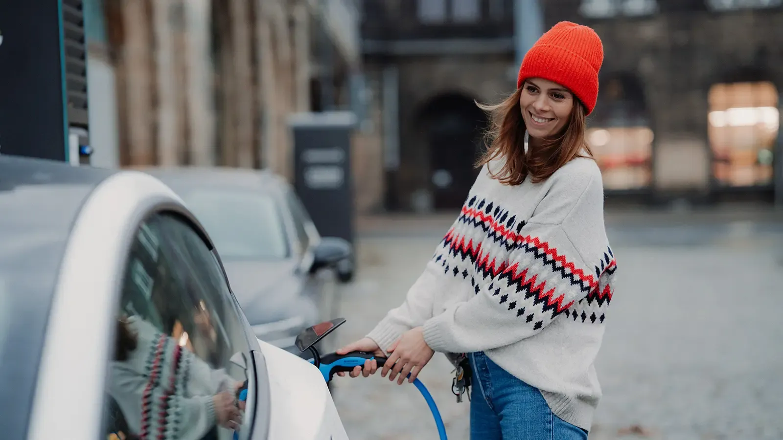 a woman charging her electric car