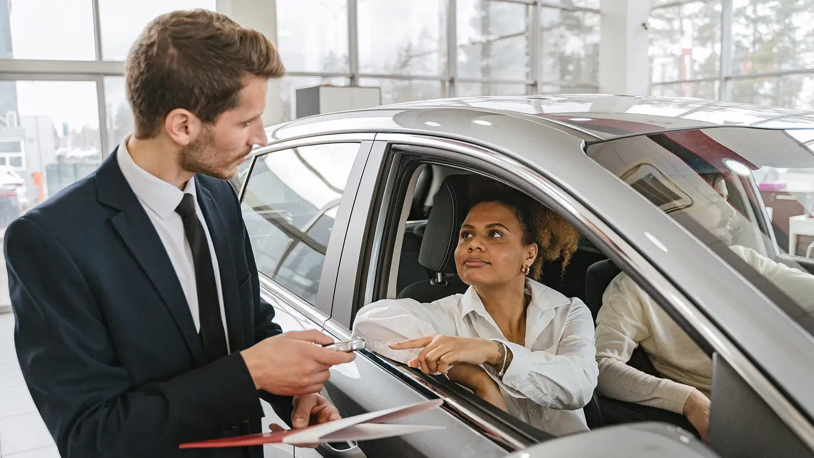 A salesman talking with a customer about a car