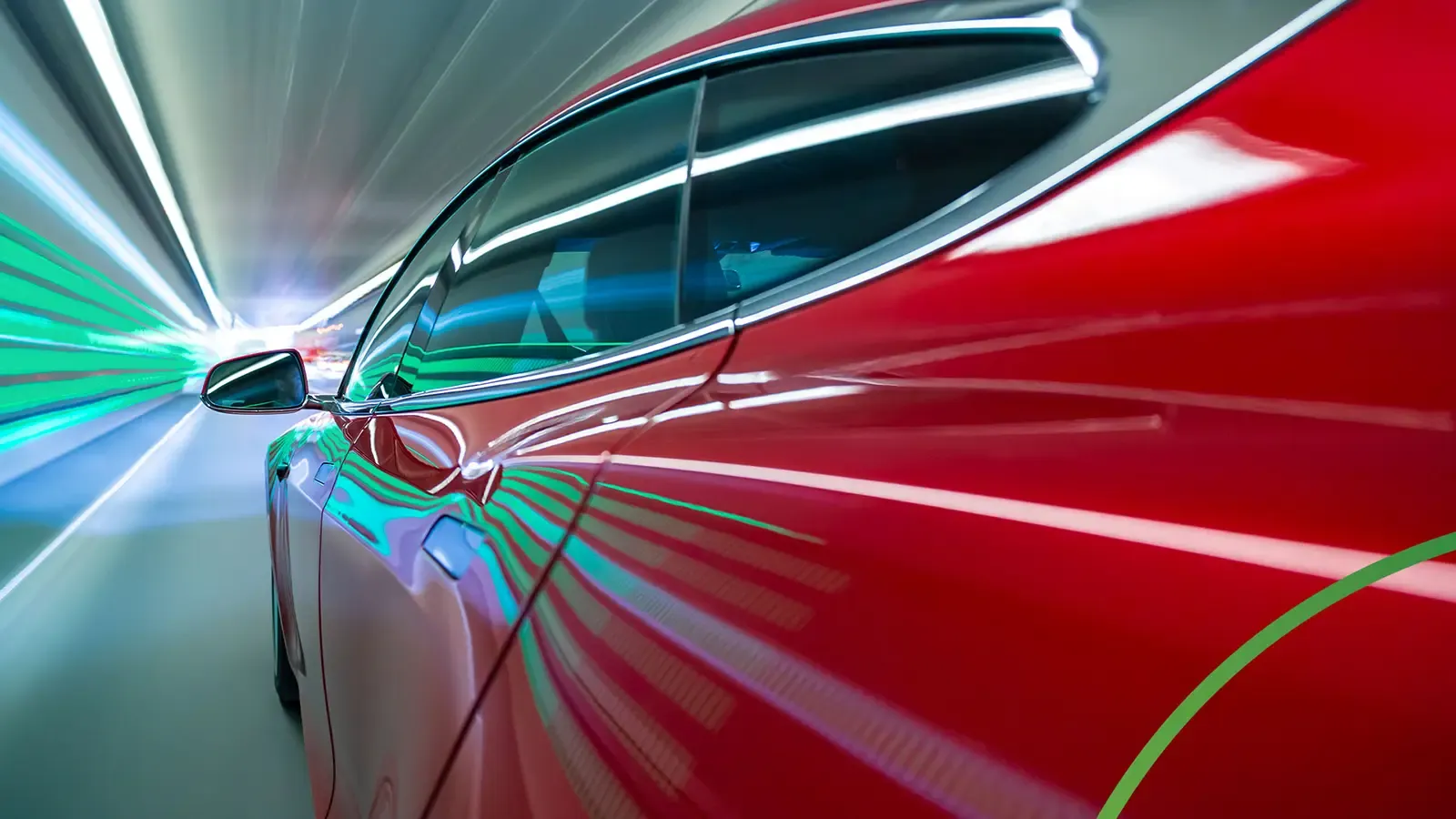 Red car speeding through a tunnel with lights