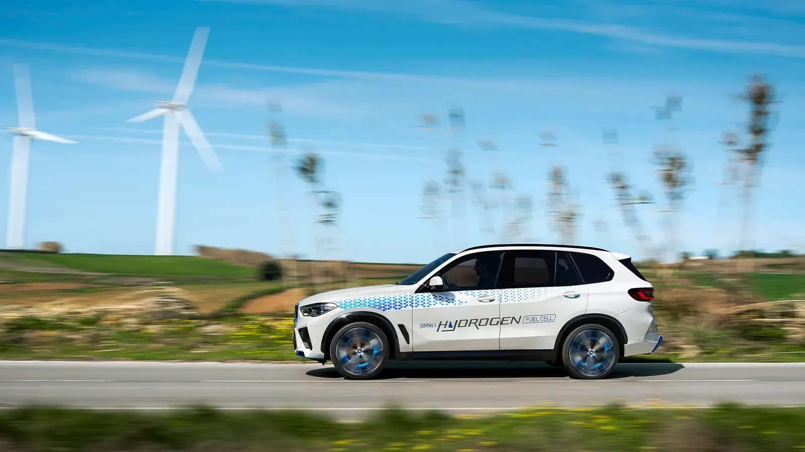 white hydrogen vehicle driving on scenic road