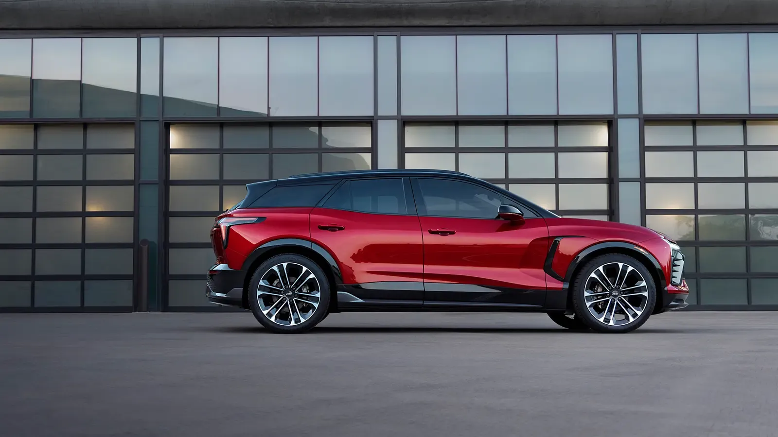a chevrolet blazer ev parked outside in front of a building with many windows