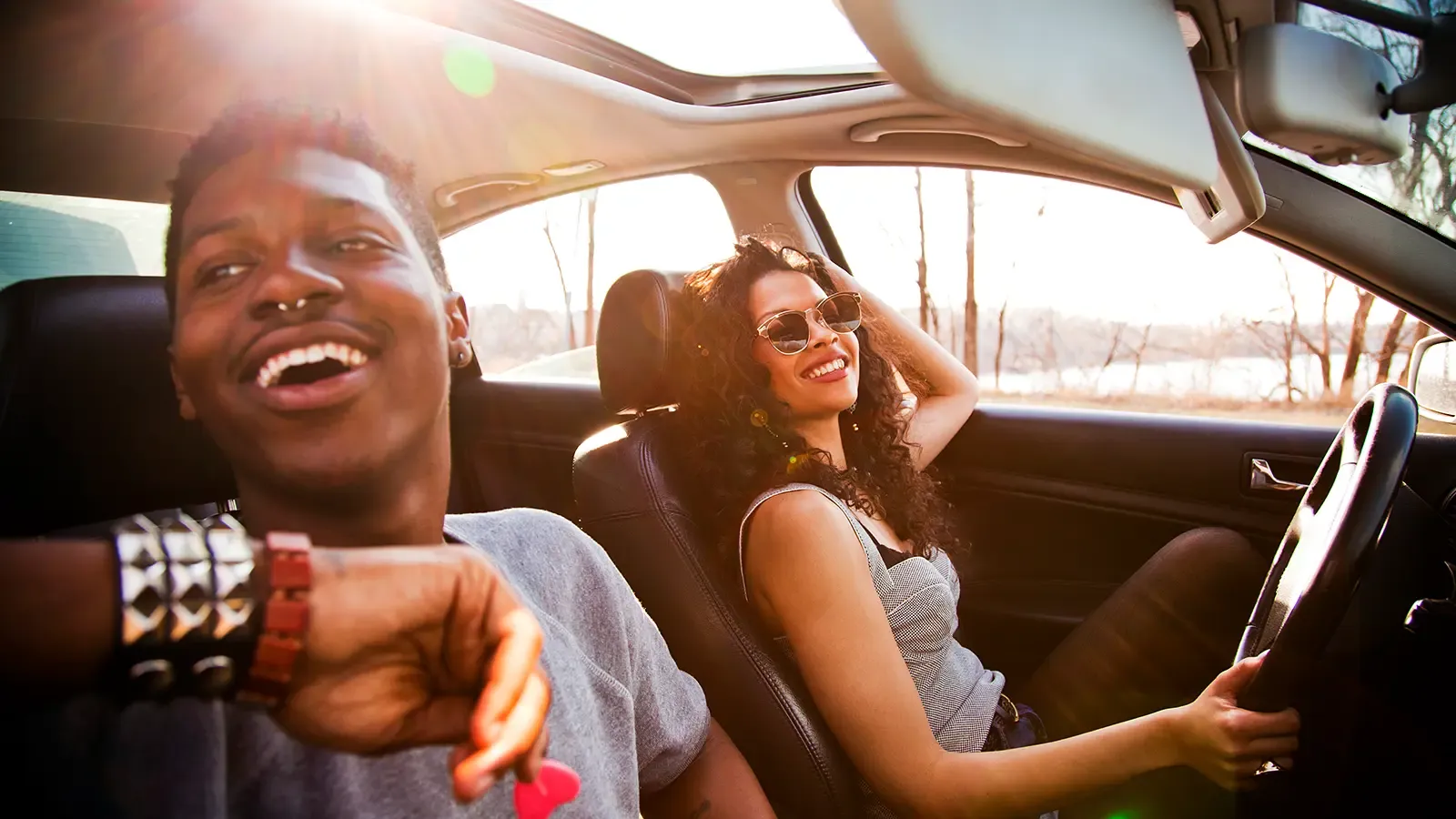 two people sitting inside a vehicle on a sunny day