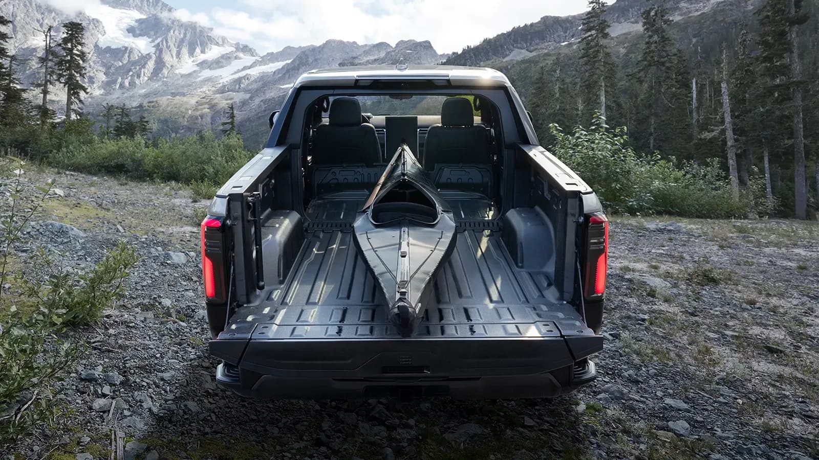 rear view of the 2024 gmc sierra ev with a kayak in the truck bed