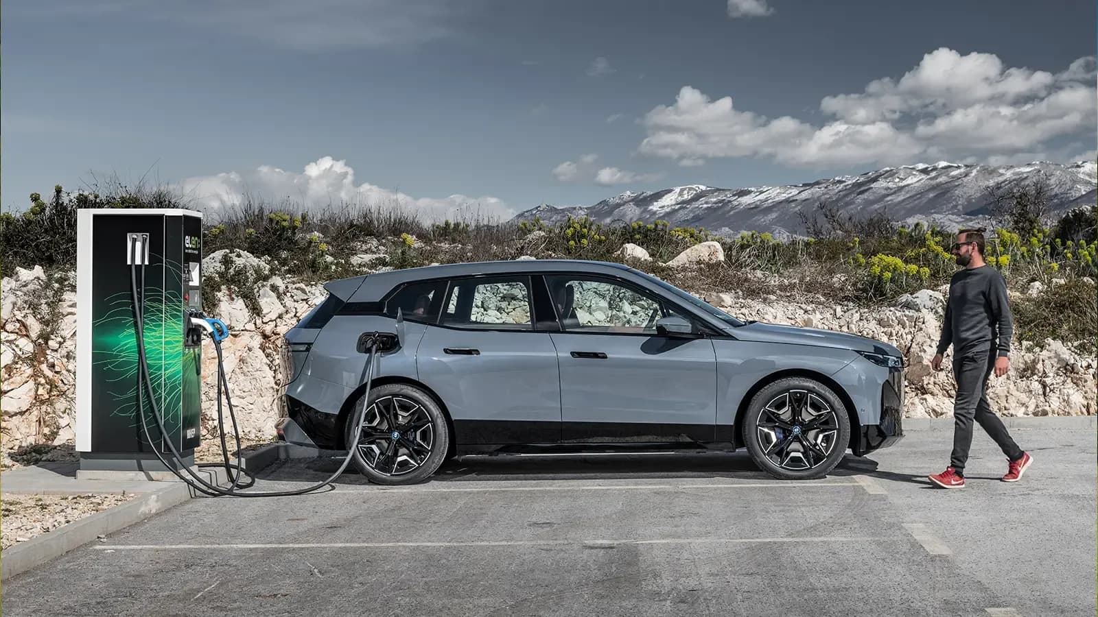 BMW iX xDrive50 charging in front of mountains