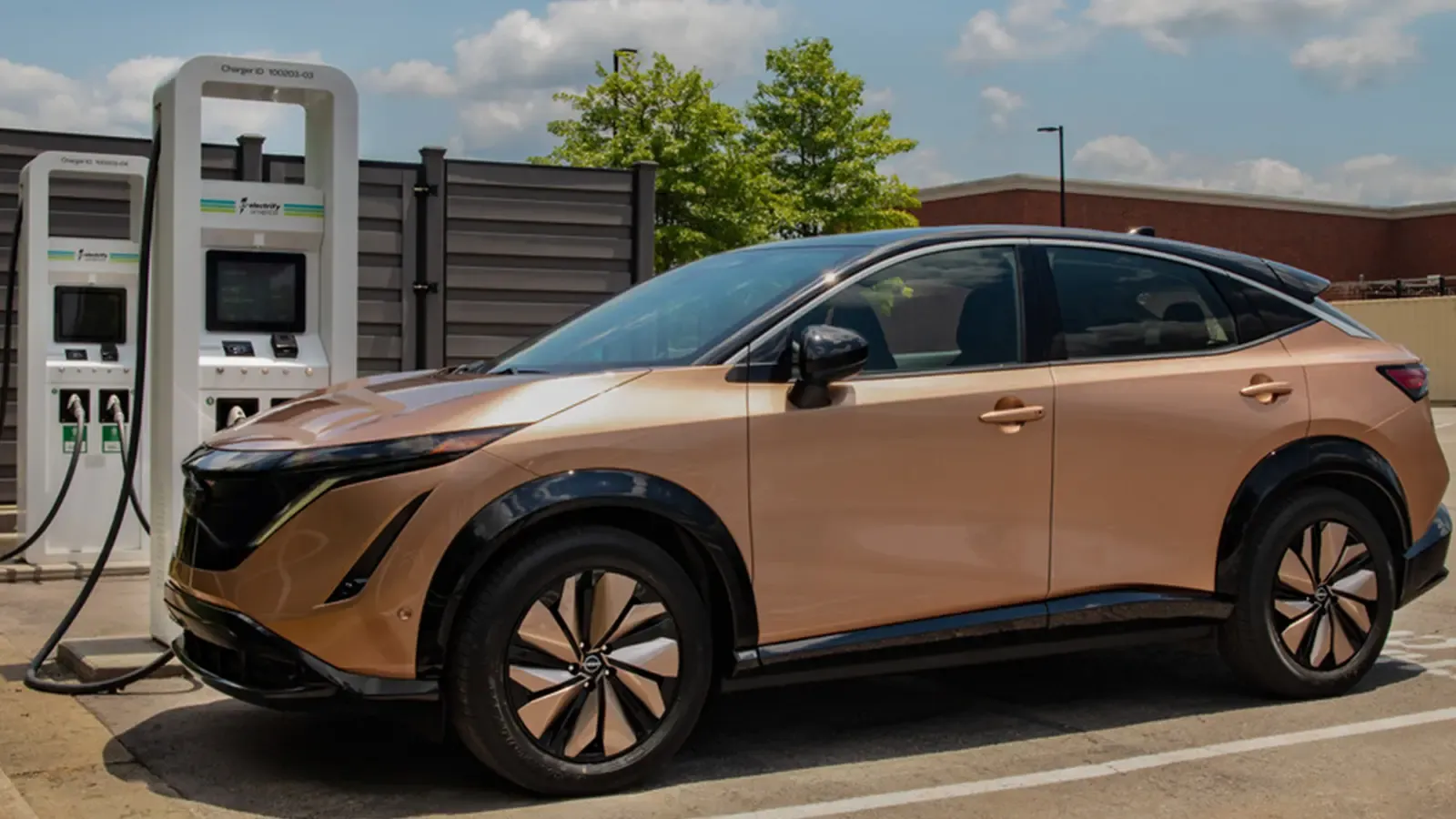Bronze Nissan Ariya charging in parking lot