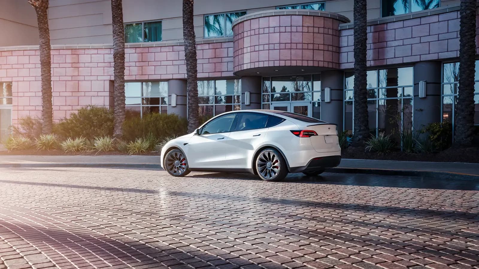 White Tesla Model Y parked in front of building
