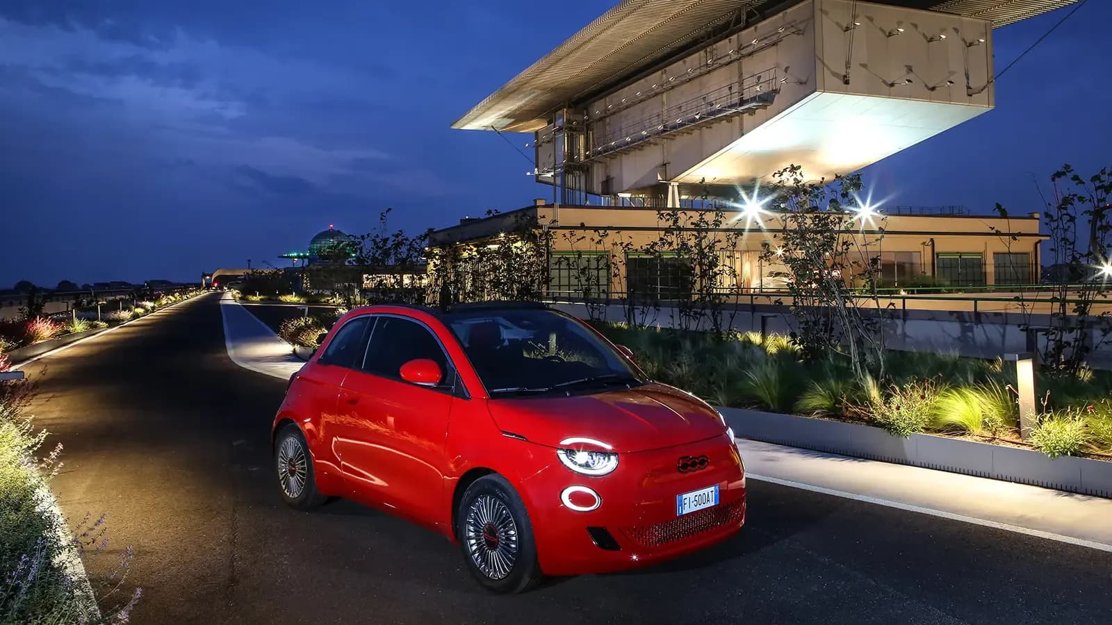 fiat 500e driving on a road at dusk