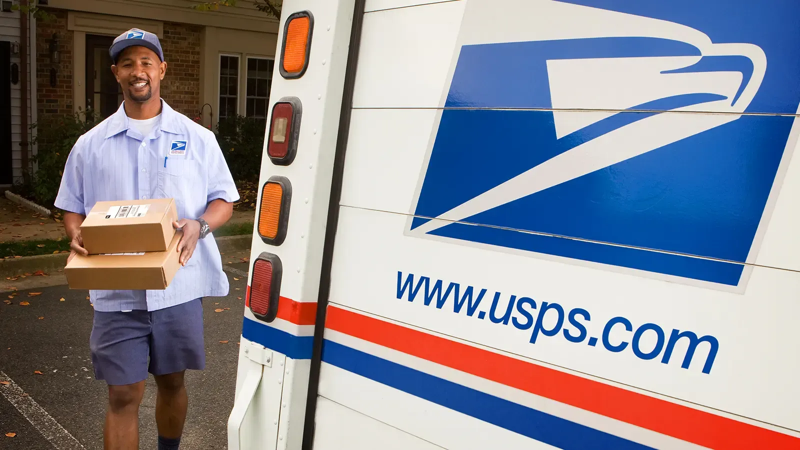 Mail man bringing packages to USPS truck