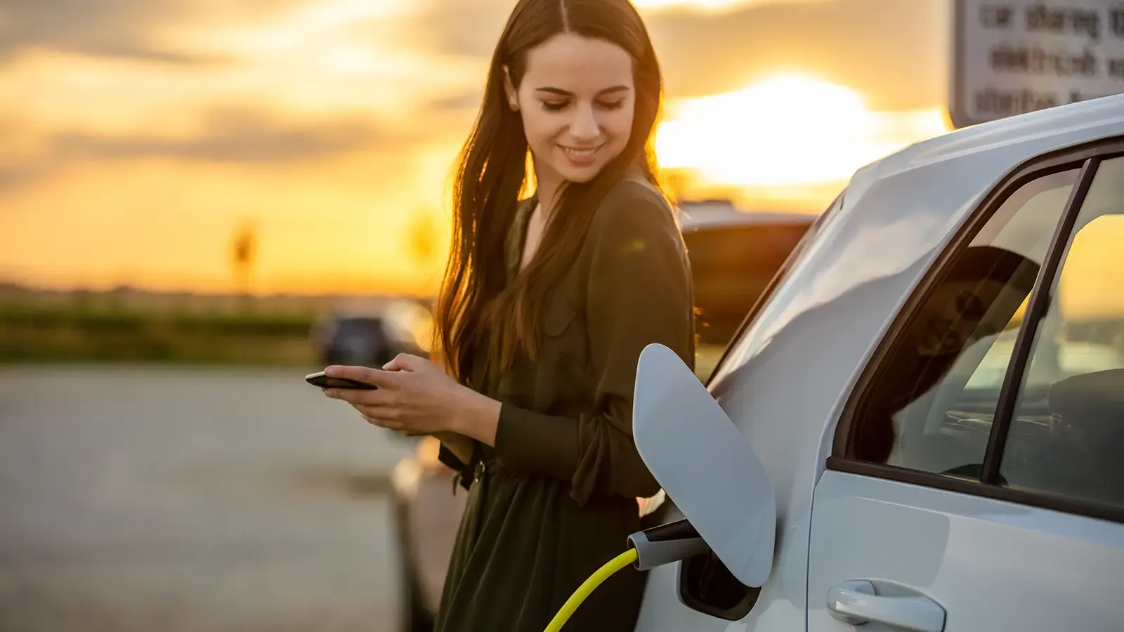 Woman happily charging her electric car