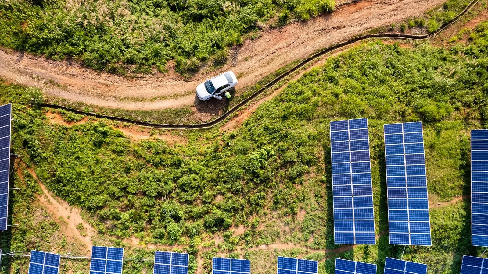 One male engineer working on the solar panel plant by car