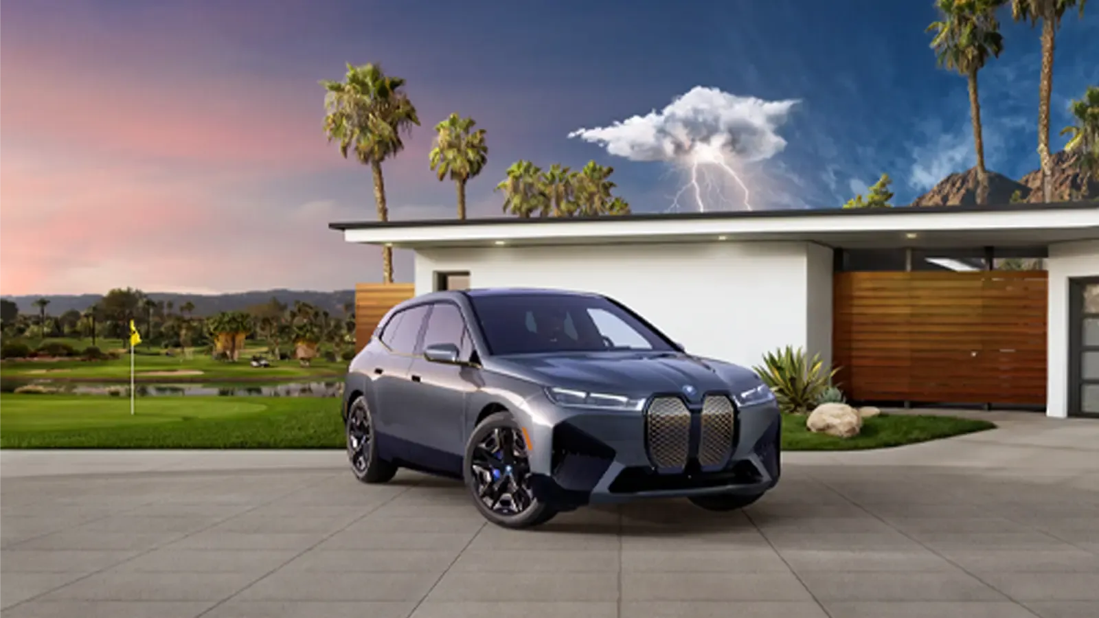 2023 BMW ix M60 parked in driveway of luxury home with lighning in the background