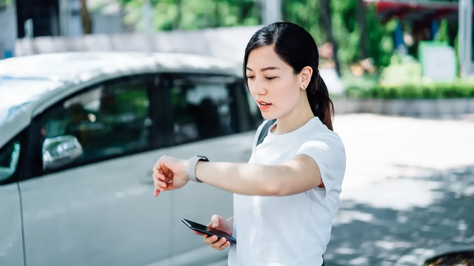 Young woman checking time on her watch