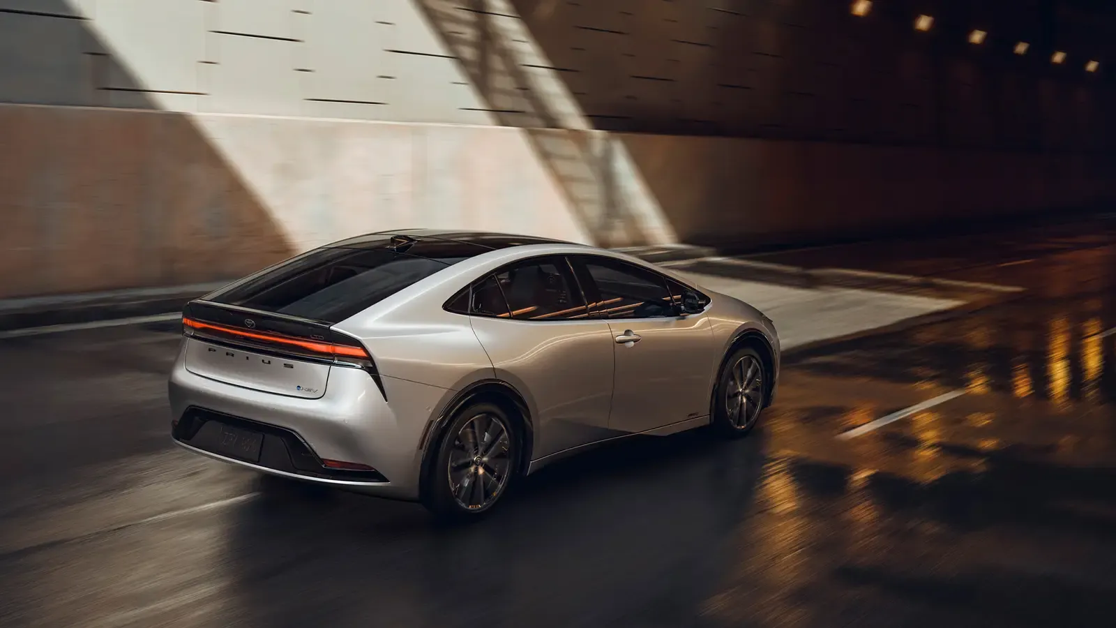2023 toyota prius driving on a road into a tunnel