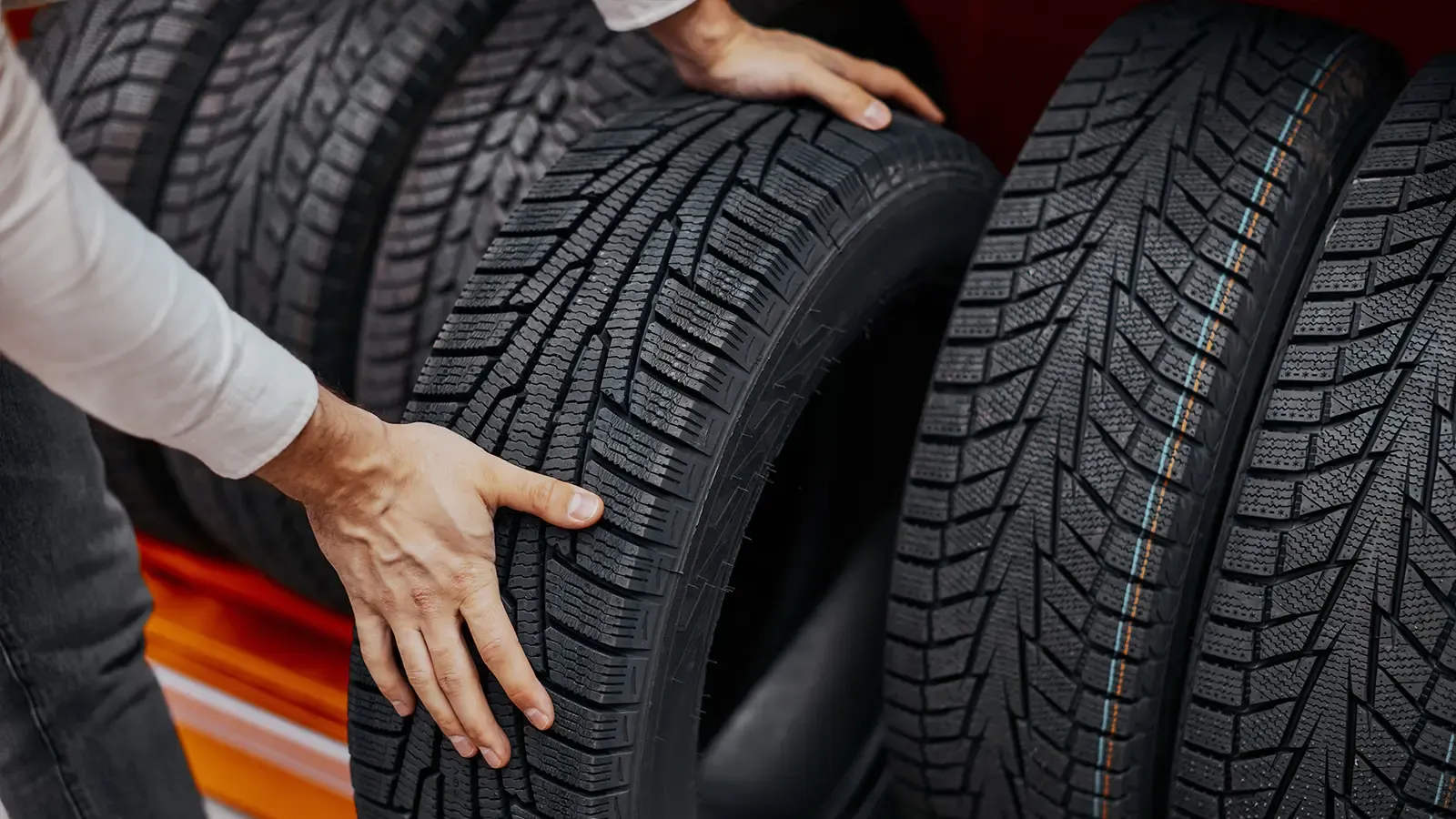 Close up of someone removing a tire from shelf.
