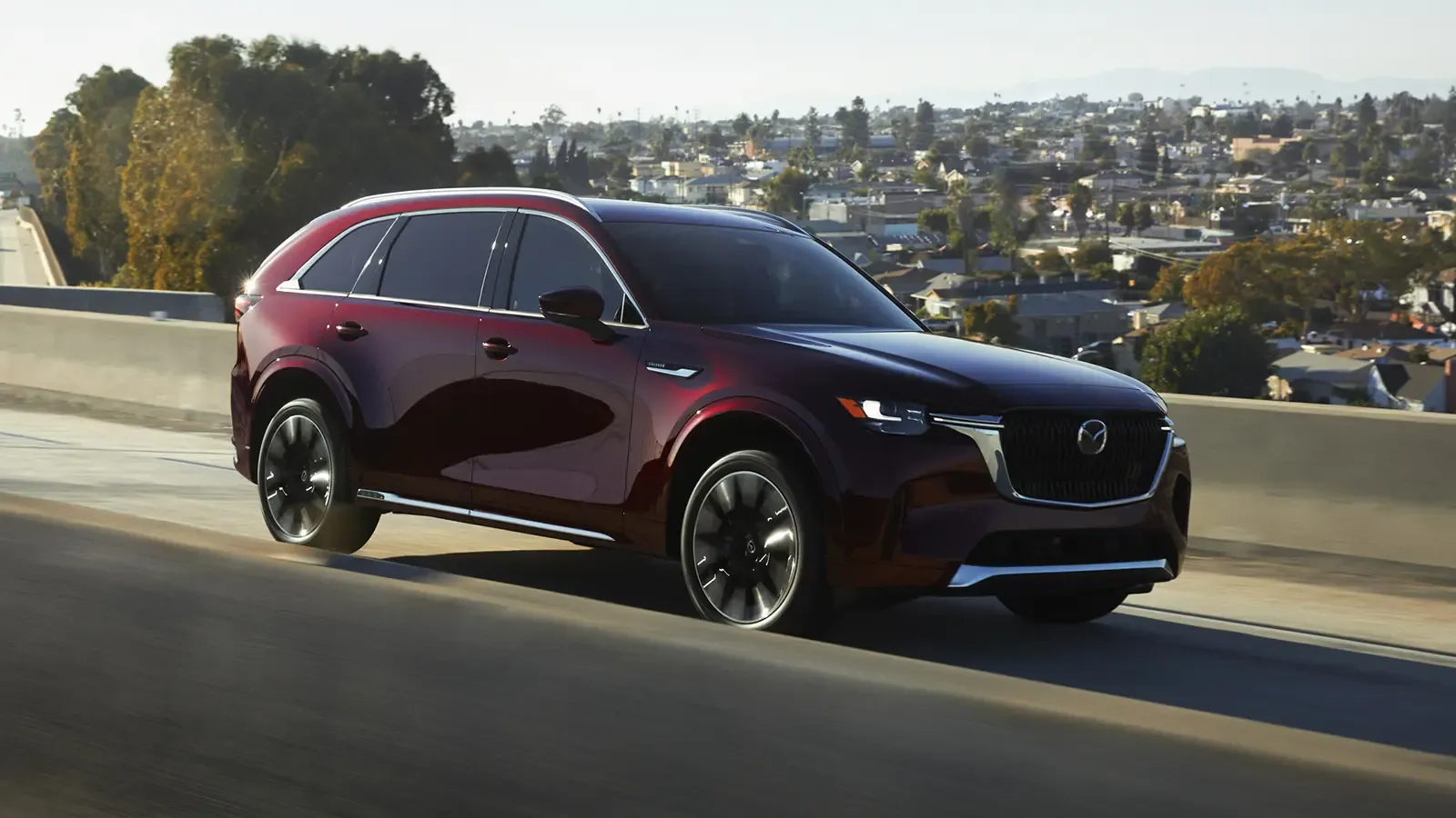 Side exterior shot of Mazda CX-90 driving on the highway.