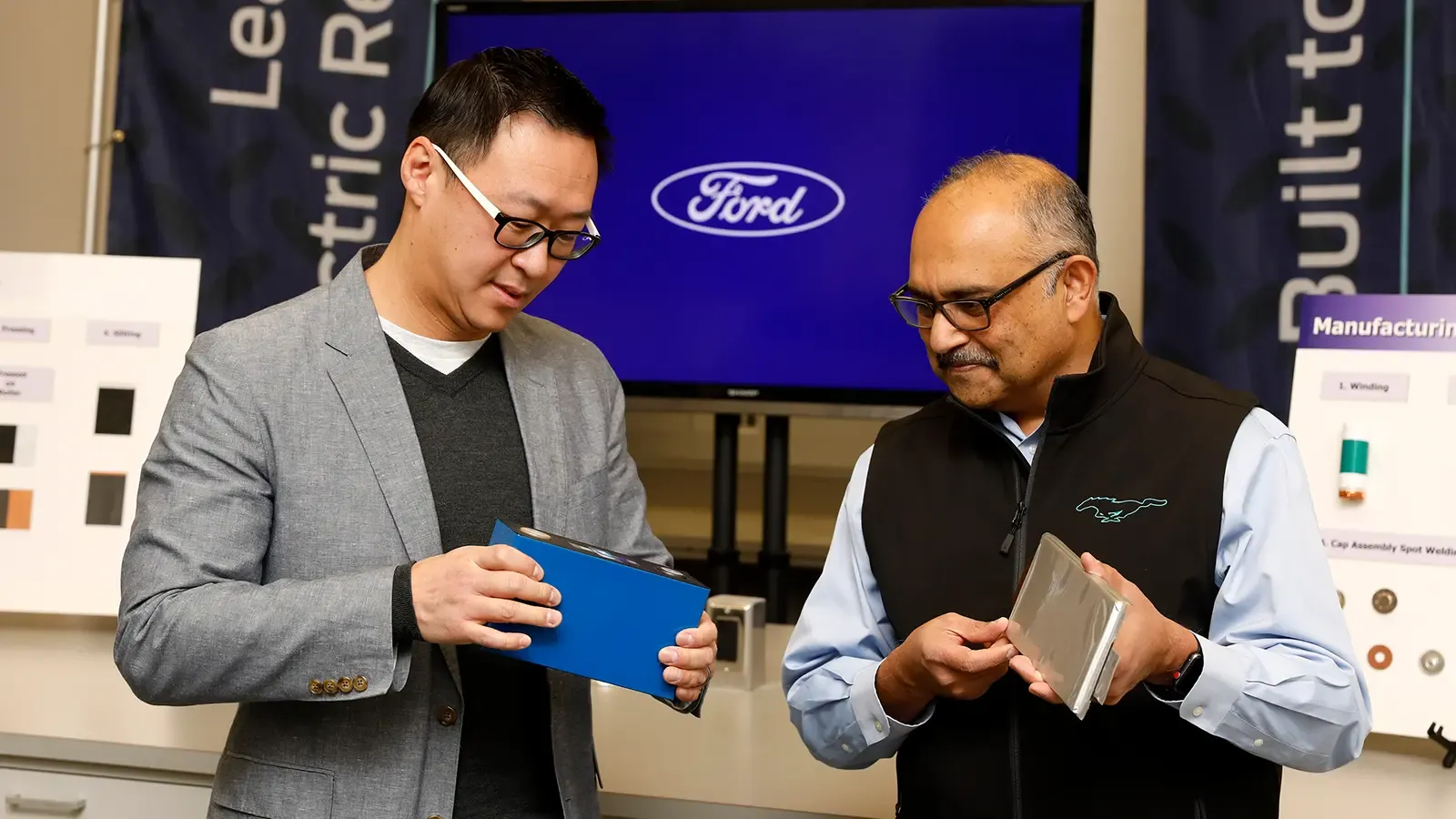 Two people reviewing the Feb 13, 2023 Ford Battery Announcement