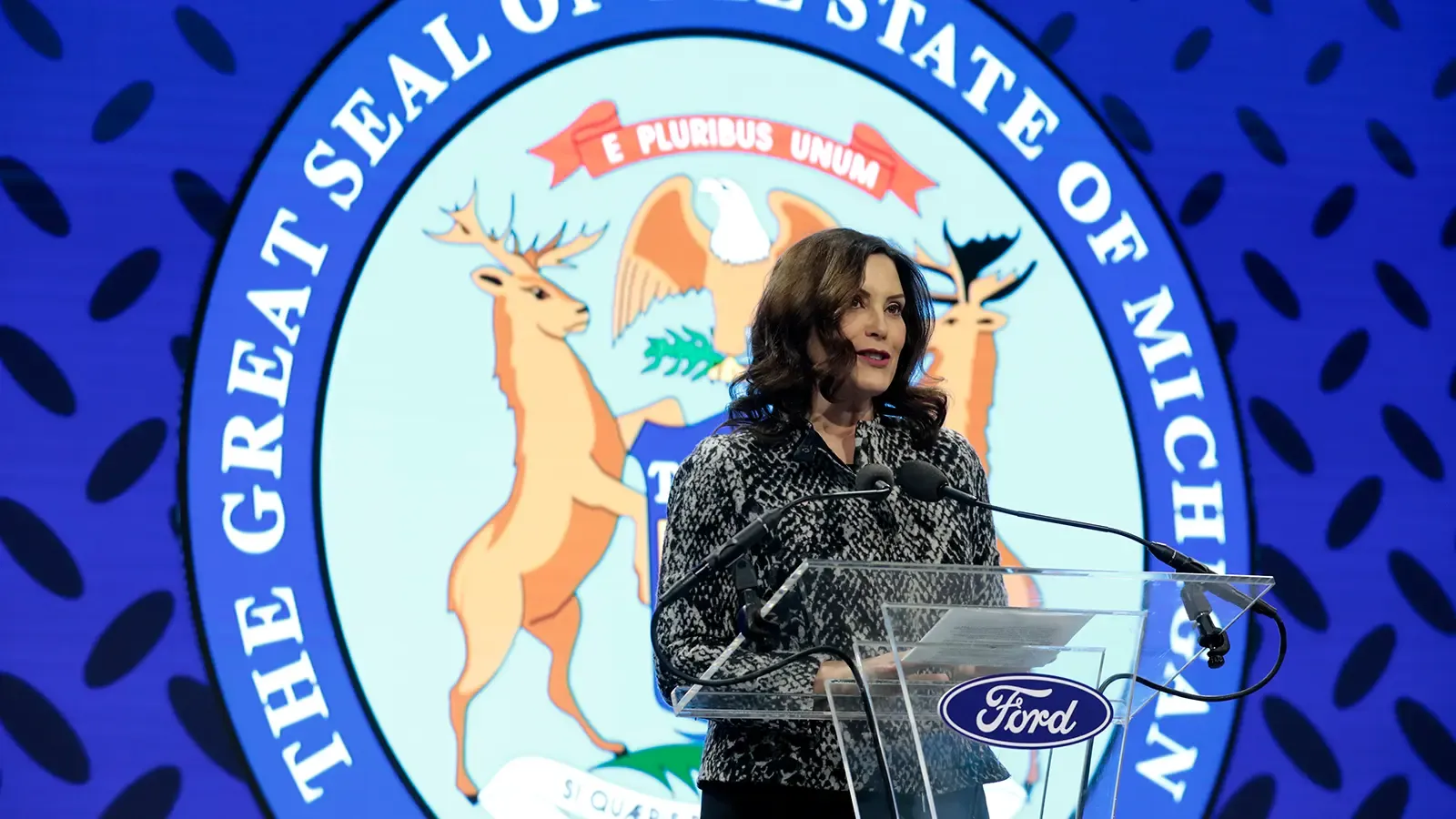 Announcement of Feb 13, 2023 Ford Battery with seal state of Michigan in background.
