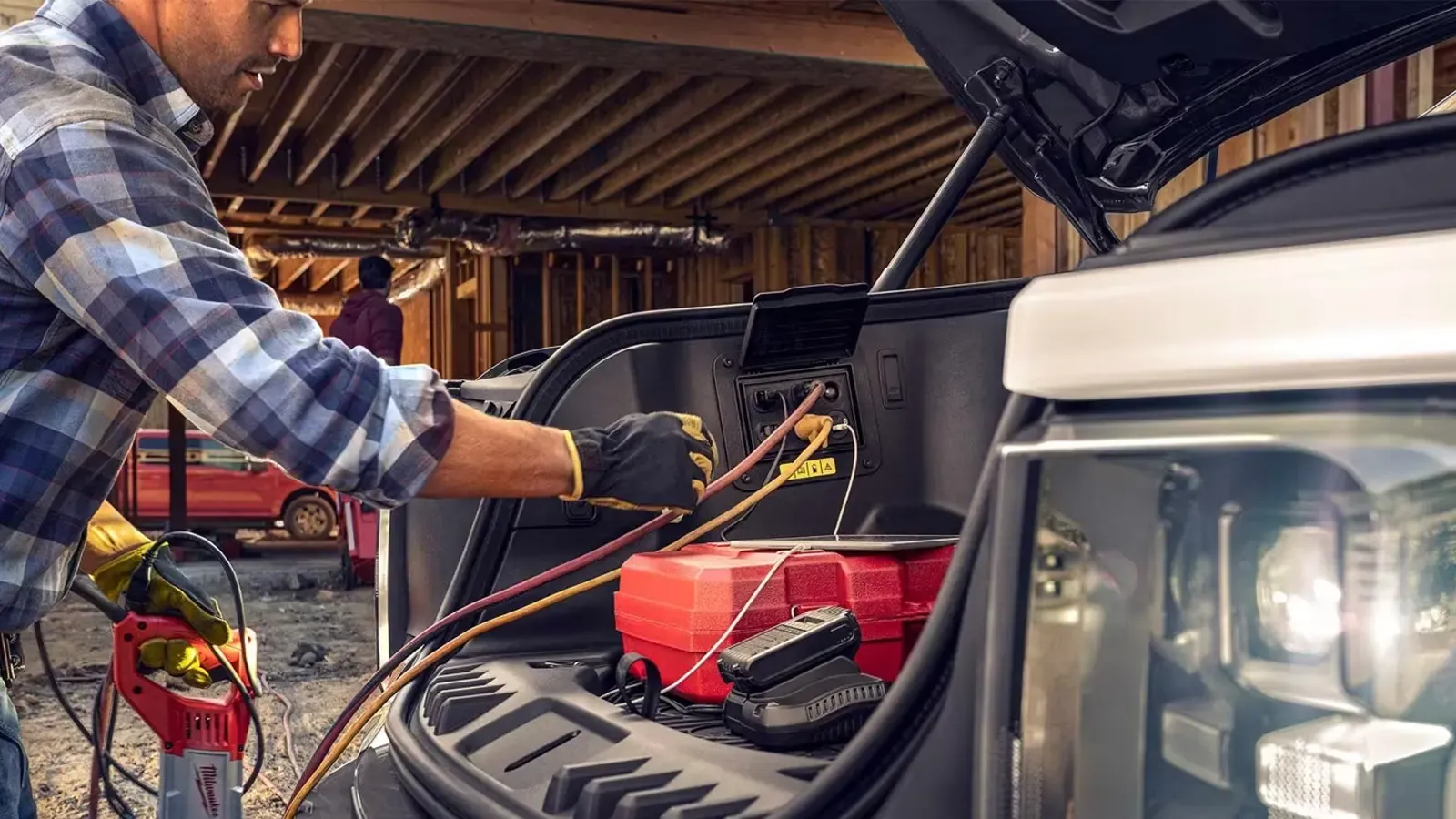 A man using the Ford F-150 Lightning frunk