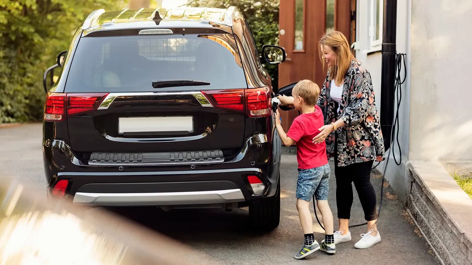 Mother and son charging their electric car