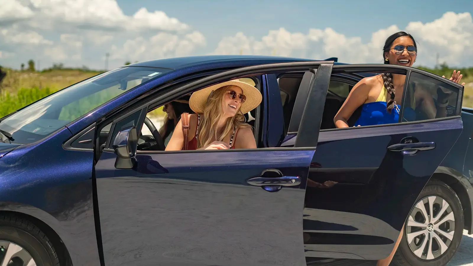 Two women exiting a hybrid Prius