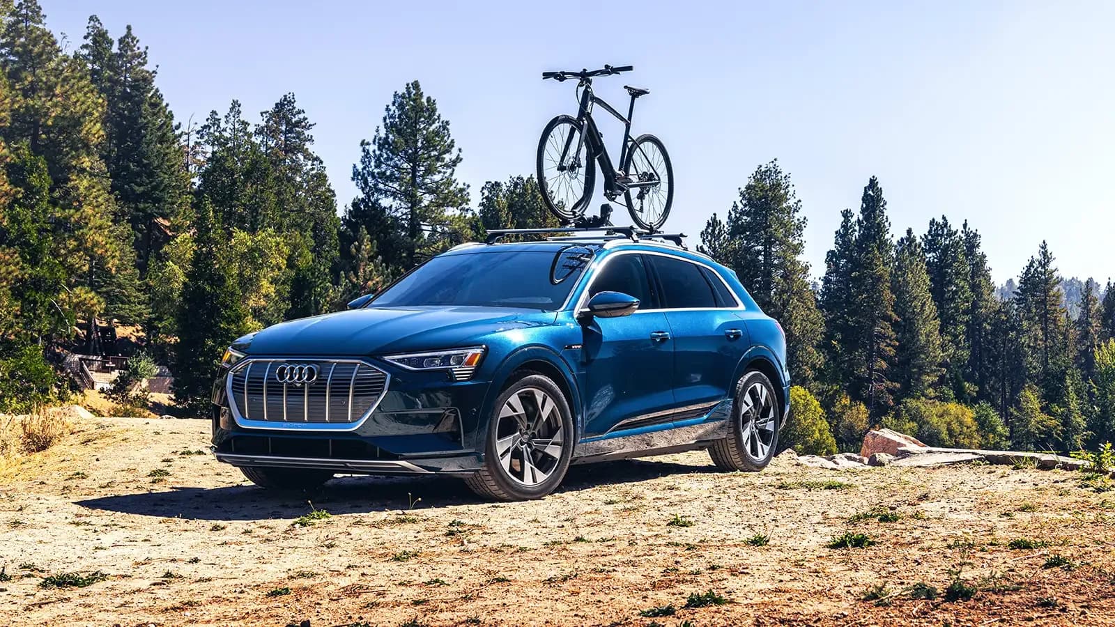 Audi e-tron parked at a camp trail with a mountain bike mounted on top