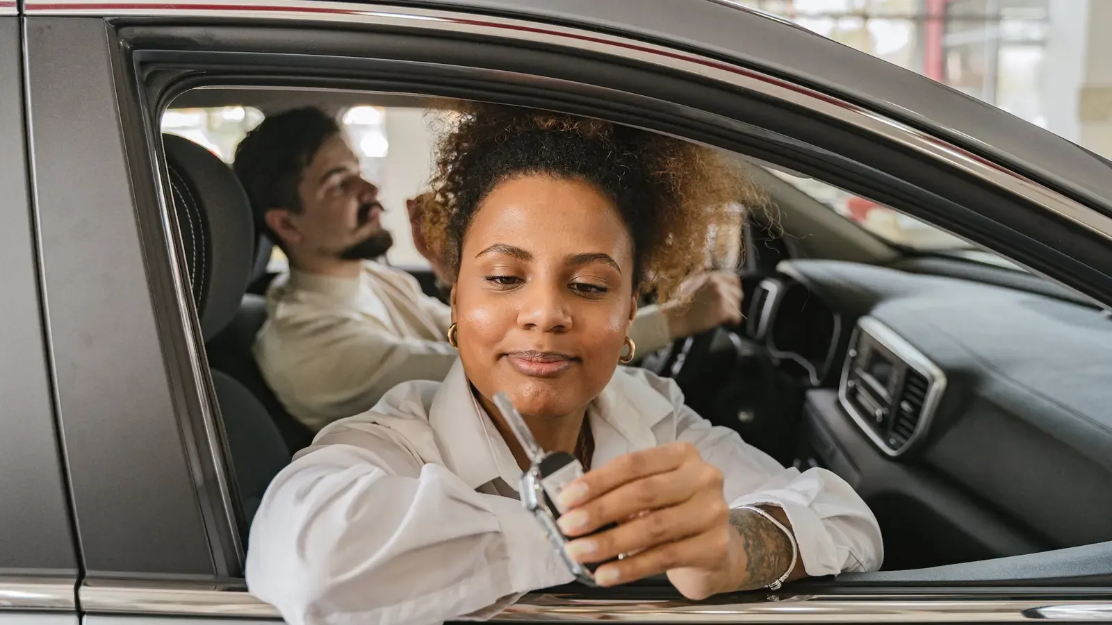Woman learning out of car window contemplating an EV Lease
