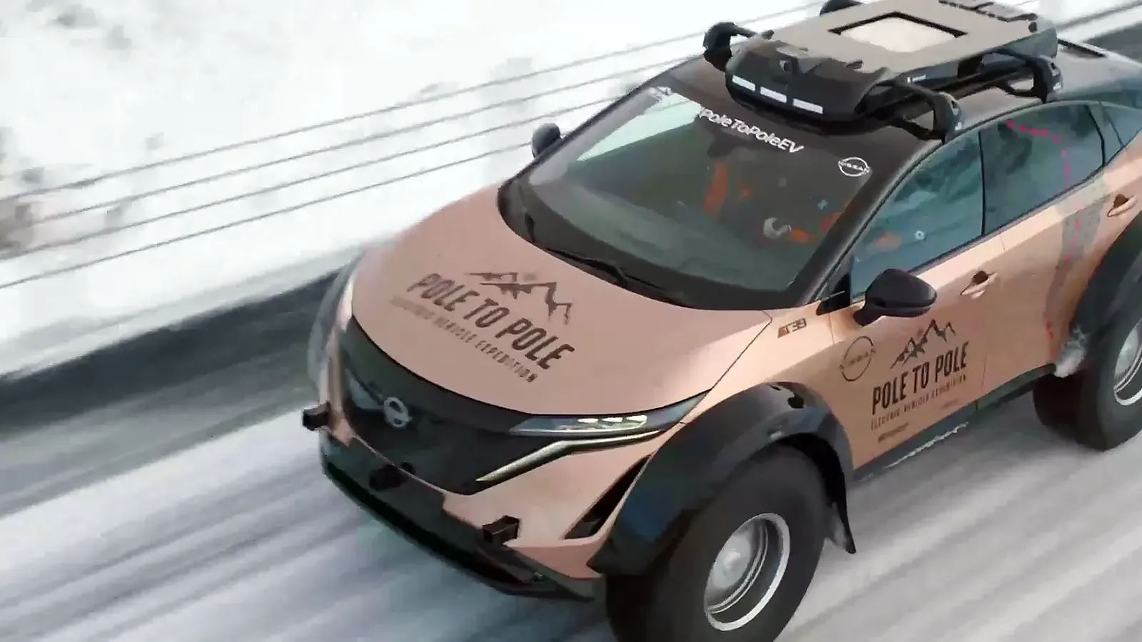 Copper colored Nissan Ariya electric car driving on a snowy road